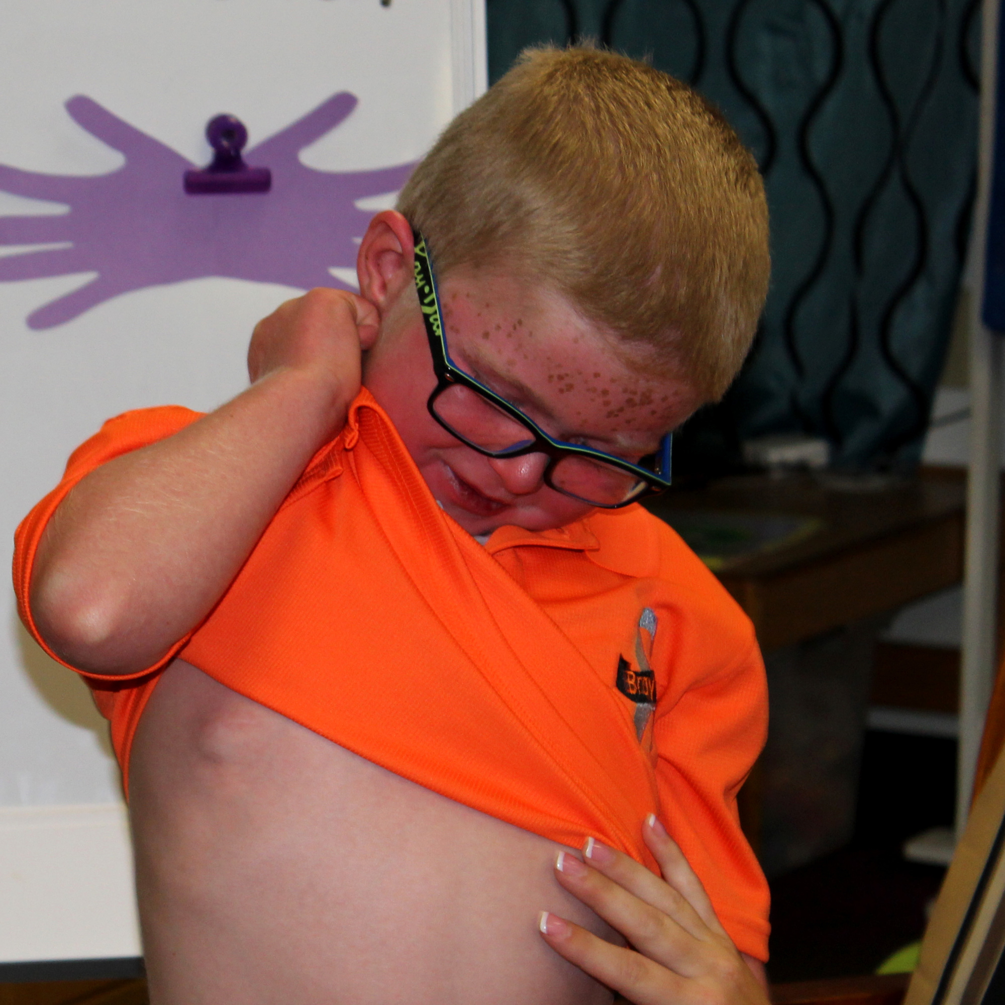 Brayden lifts his shirt to show what a port looks like. Photo by Jacque Estes