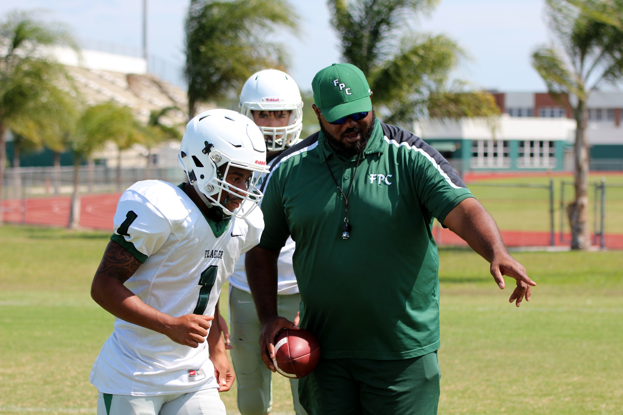 FPC head coach Tommy Moody teaches Que'Shaun Byrd where to line up during practice.