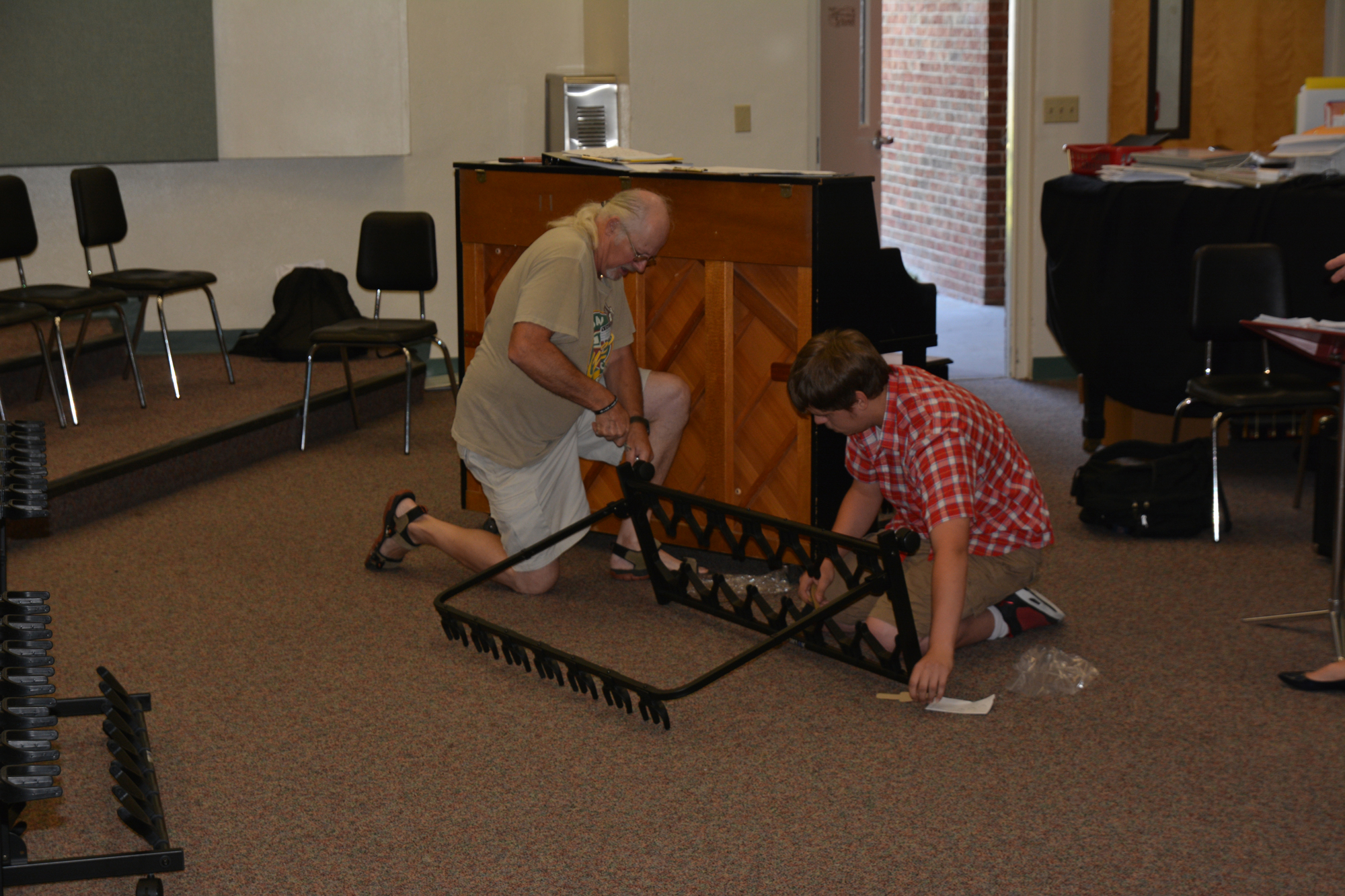 Victor Stockwell puts together the donated guitar stands with his grandson Justin Fifiele.