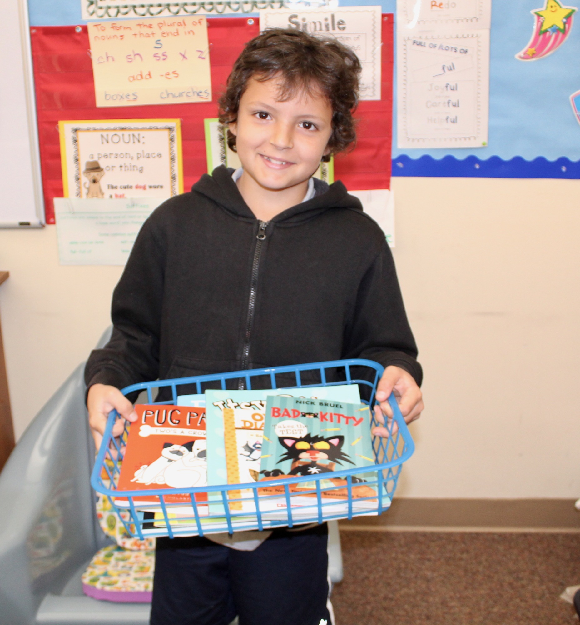 Rymfire second-grader Caleb Hether poses with a basket of Scholastic books he won. Photo courtesy Melanie Tahan