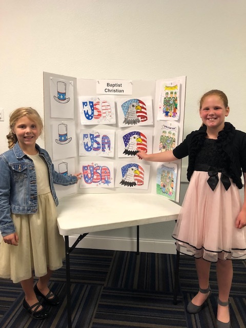 Eleanor and Sophia Snedeker pose by their colorings at the VFW contest. Photo courtesy of Stephanie Sumler