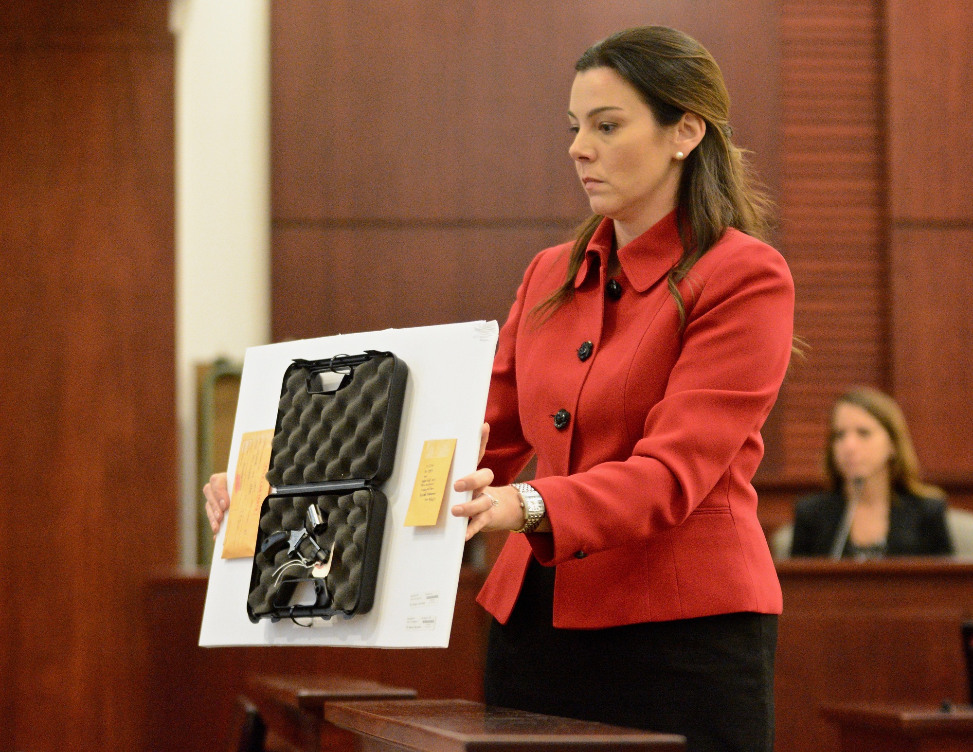 Prosecutor Jennifer Dunton shows the jury the firearm used to kill Charles 
