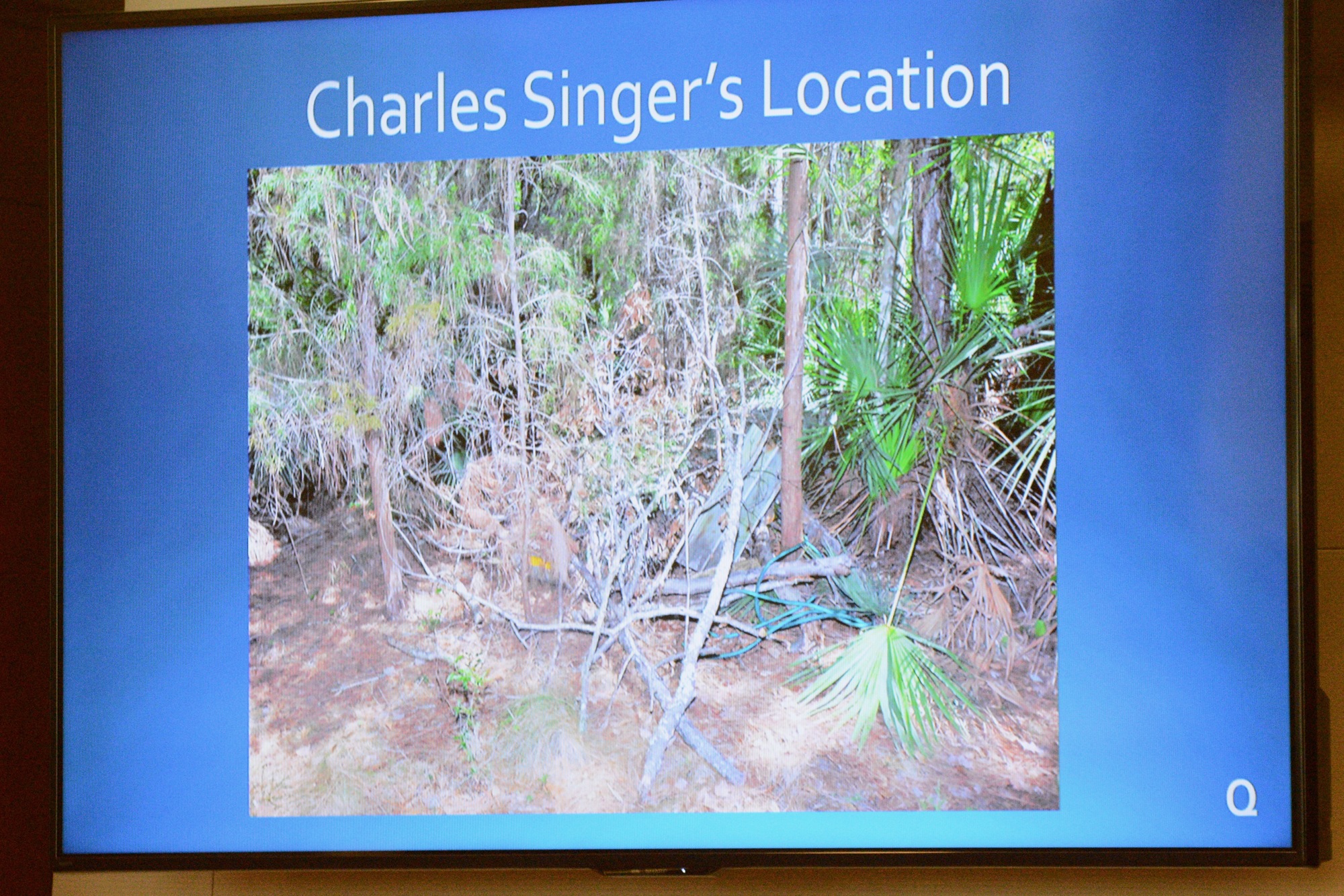 A prosecution presentation slide showed the overturned jon boat and pile of brush under which detectives found Charles Singer's  body.