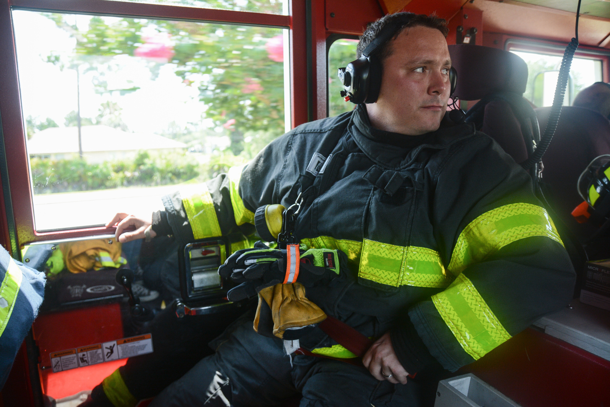 Firefighter-EMT Chris Strozier sits in the back seat of Fire Engine 23 on the way to a call. Photo by Paige Wilson