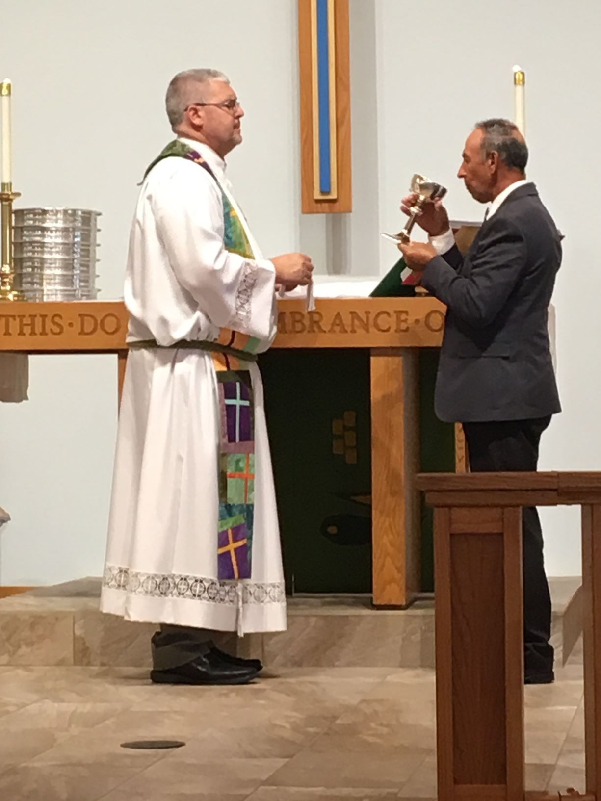 Pastor Vince Iocona of St. Mark by the Sea stands by Pastor Viktor Ostapenko, of Emmanuel Slavic Evangelical Church, who takes communion during the unity service. Photo courtesy of Sandra Trautwein