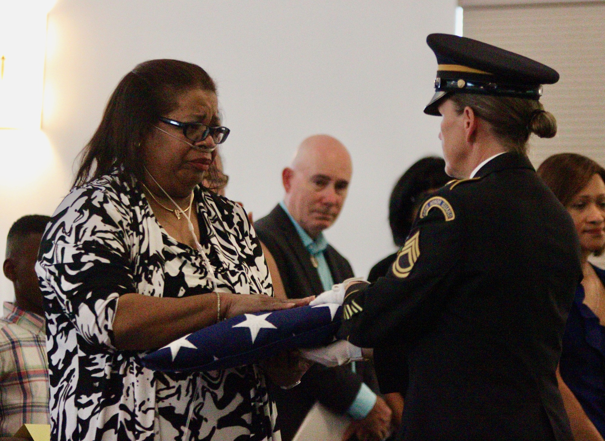 Wendy Gordon receives an American flag honoring her aunt Violet Gordon, who was  one of the first black Women’s Auxiliary Army Corps in World War II. Photo by Ray Boone