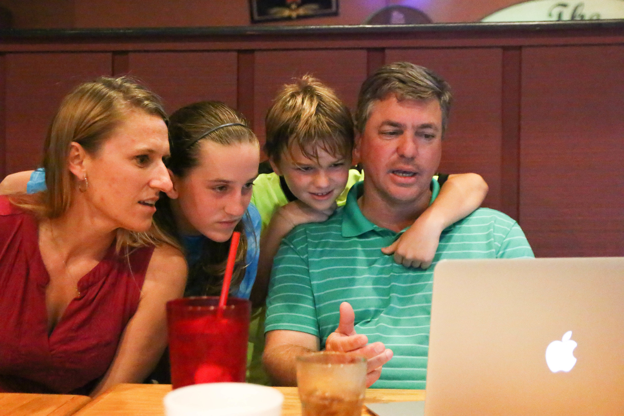 Brooke, Hailey, Garrett and Trevor Tucker watch the live election results on a laptop at Woody's BBQ. Tucker, the School Board District 4 incumbent, beat challenger Paul Anderson. Photo by Paige Wilson