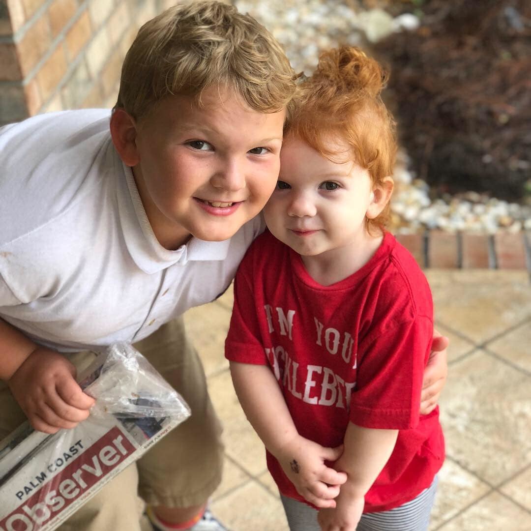 Wyatt and Scout Davis hold up a copy of the Oct. 25 issue of the Palm Coast Observer. Photo courtesy of Julie Davis