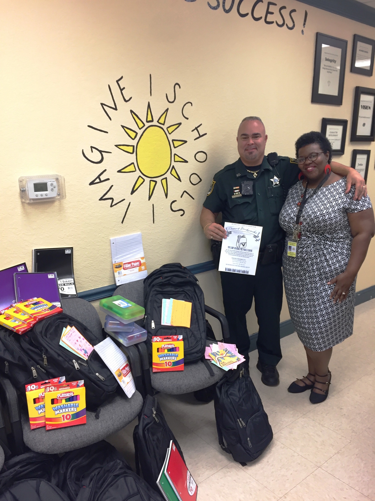 Imagine School at Town Center School Resource Deputy Lilavois and Registar LaToya Taite-Headspeth pose with the school supplies that will be donated to those affected by Hurricane Michael. Photo courtesy of ISTC
