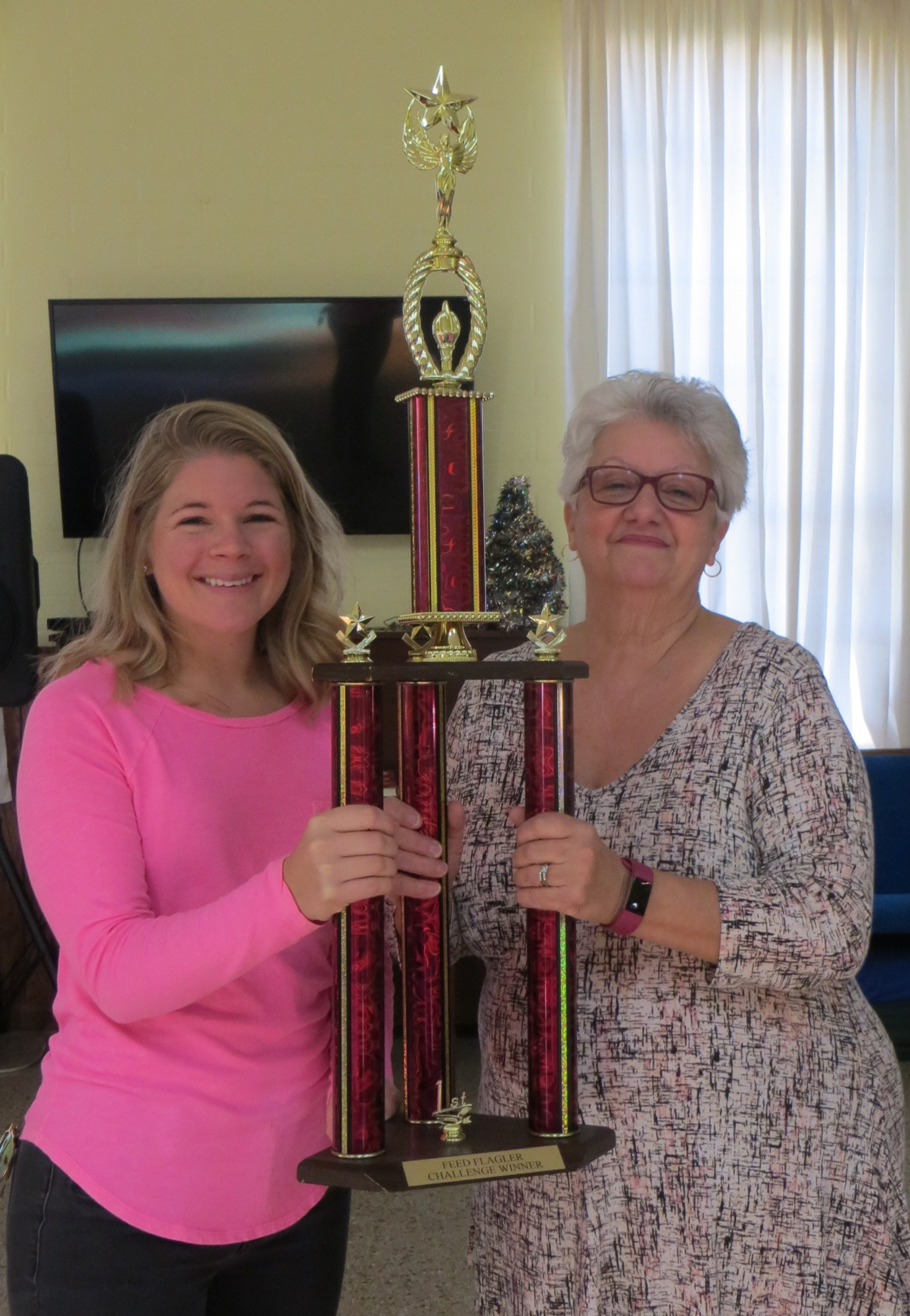 Chicks with Cans representative Maureen Walsh holds up the first place trophy for largest amount of food collected, with Dottie Colletta, of Feed Flagler. Courtesy photo