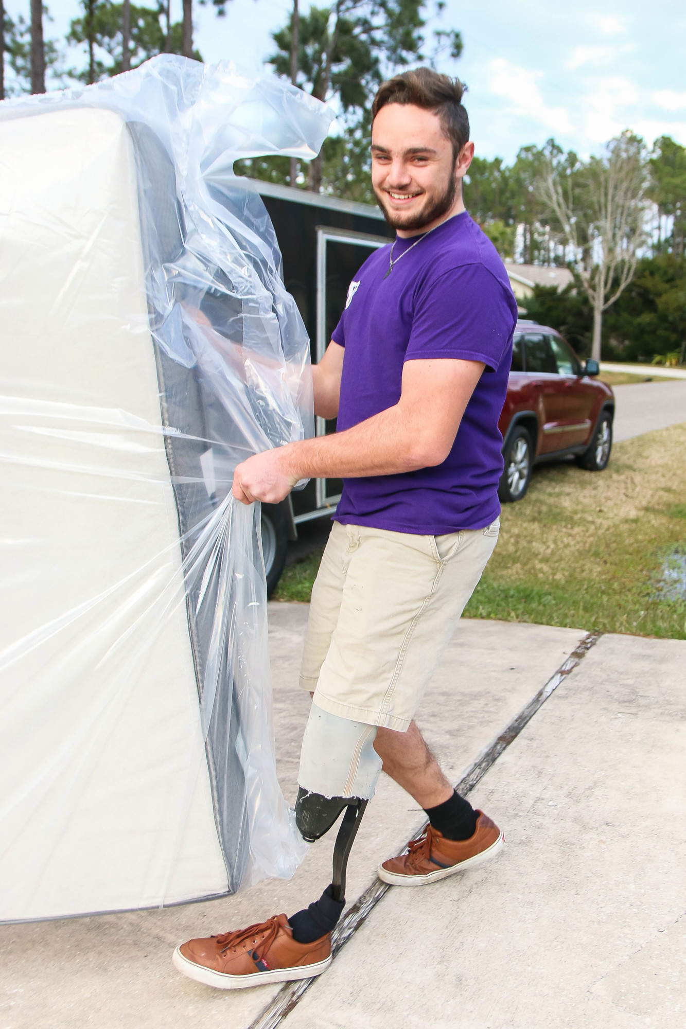 Tyler Jacques carries a mattress into a customer's home. Photo by Paige Wilson