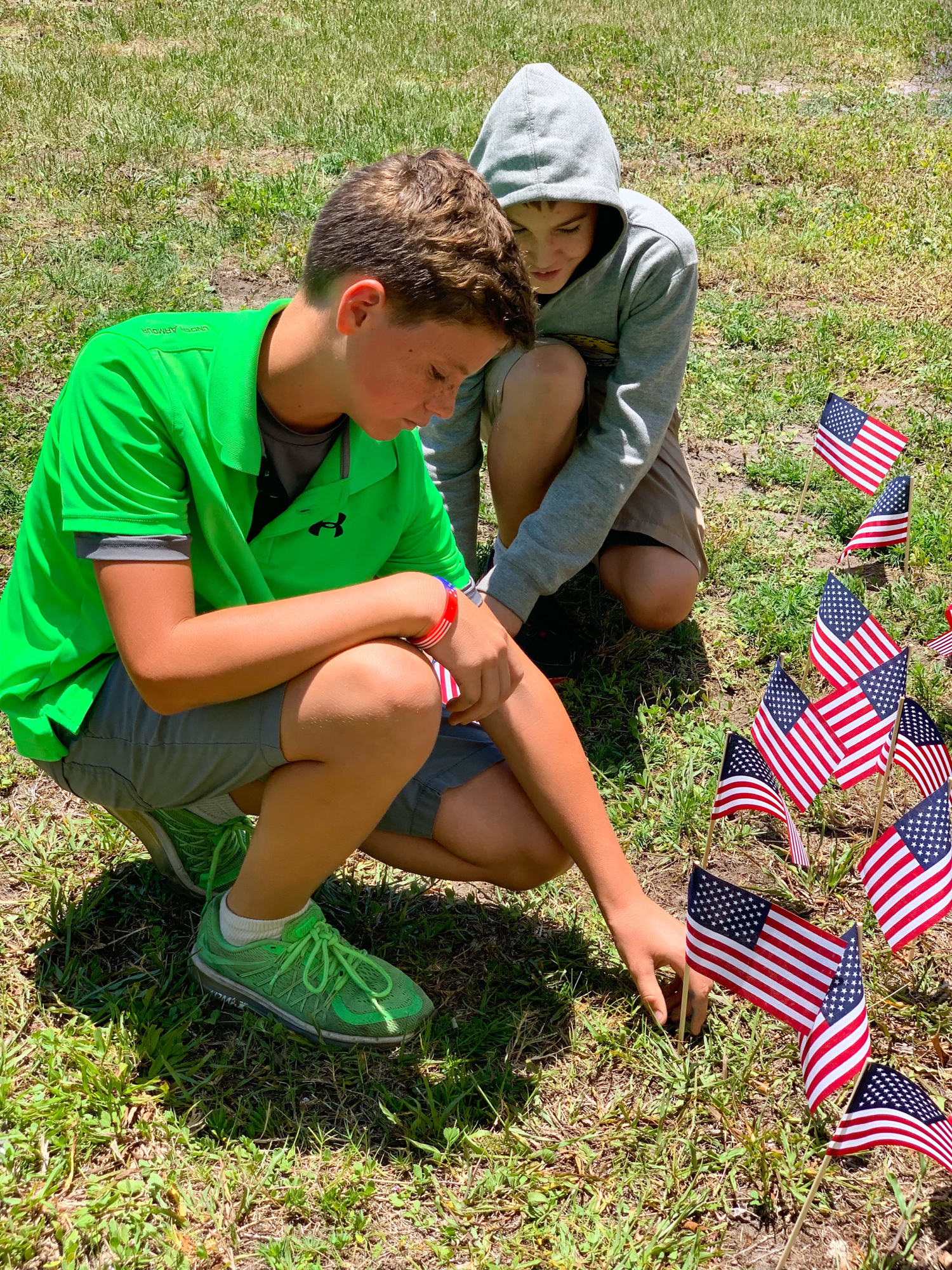 BES fifth graders Luke Middleton and John Melton plant American flags in honor of Memorial Day. Photo courtesy of Carmen Stanford