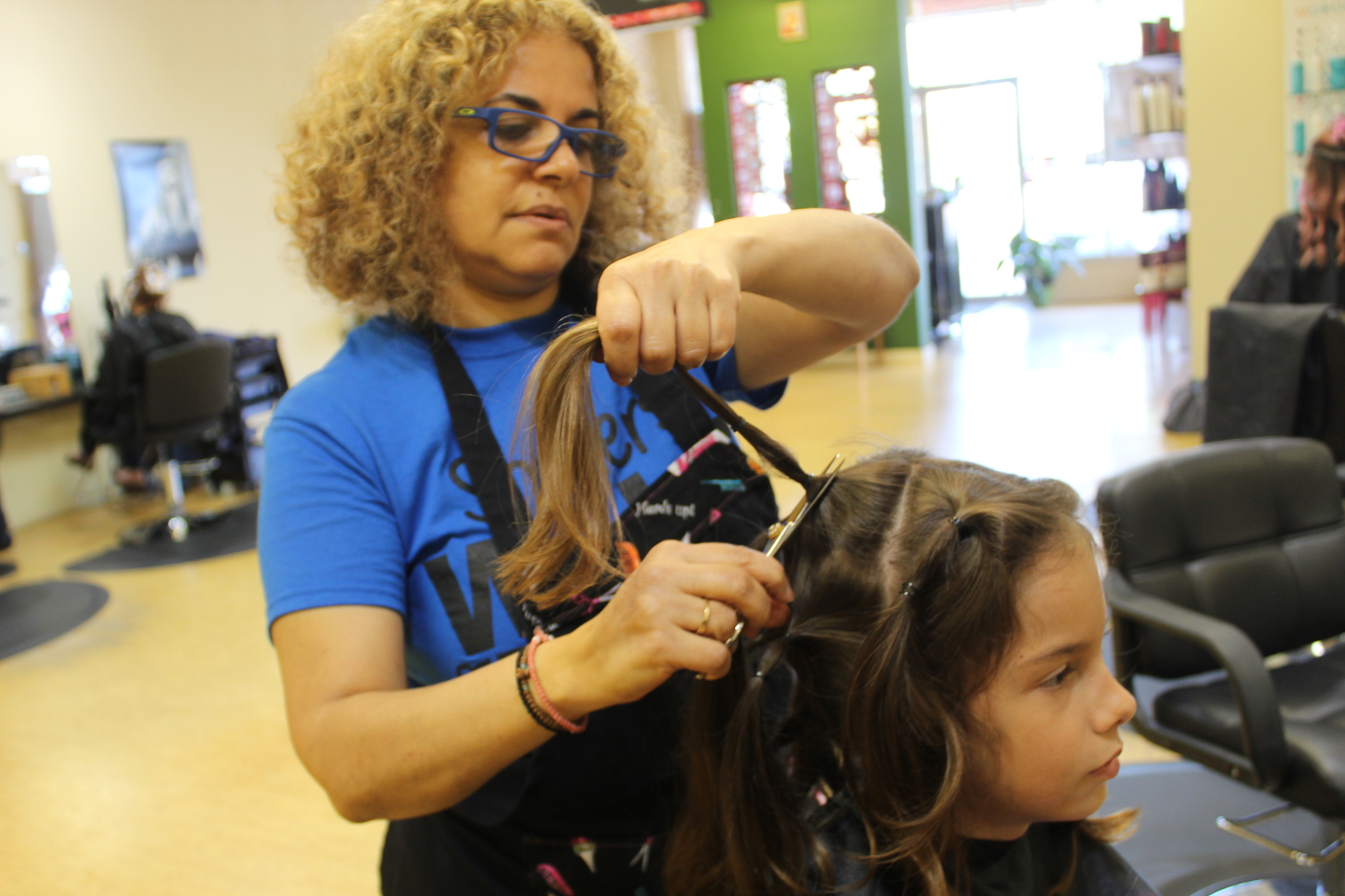 Linda Samaan snips the first ponytail on Madera's head at City Look Salon on Oct. 6. Photo by Jarleene Almenas