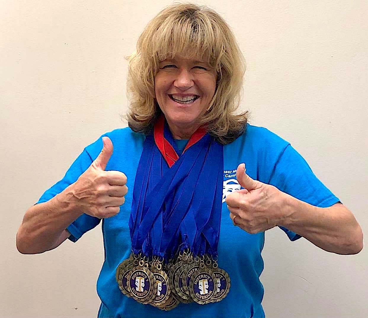 Ann Paris, who has been a theater teacher since 1987, poses with the medals won by her Buddy Taylor students in March. Courtesy photos