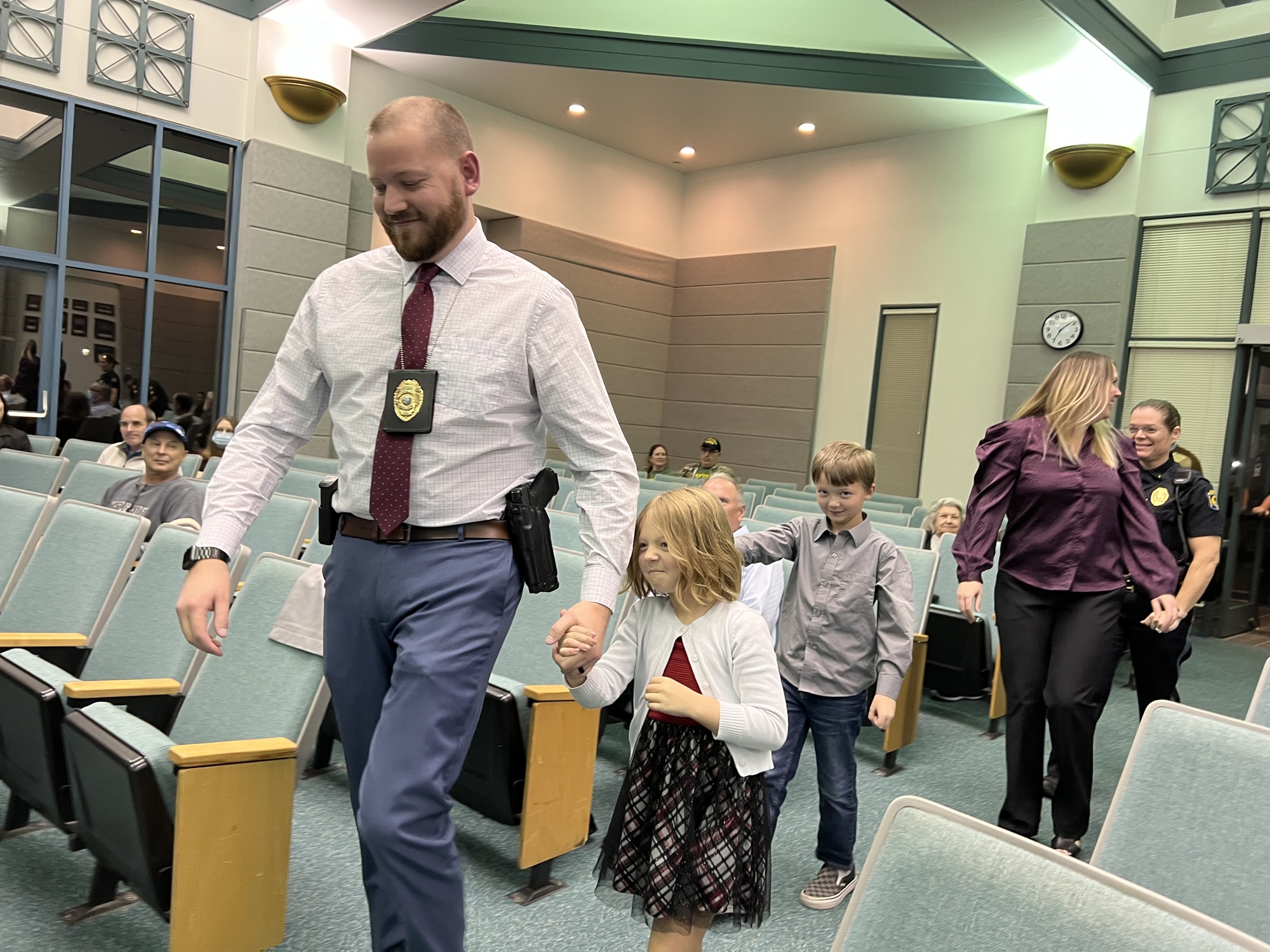 Detective Thomas Garcia leads his family to the front of the City Commission chambers to be recognized for winning his award. Photo by Brian McMillan