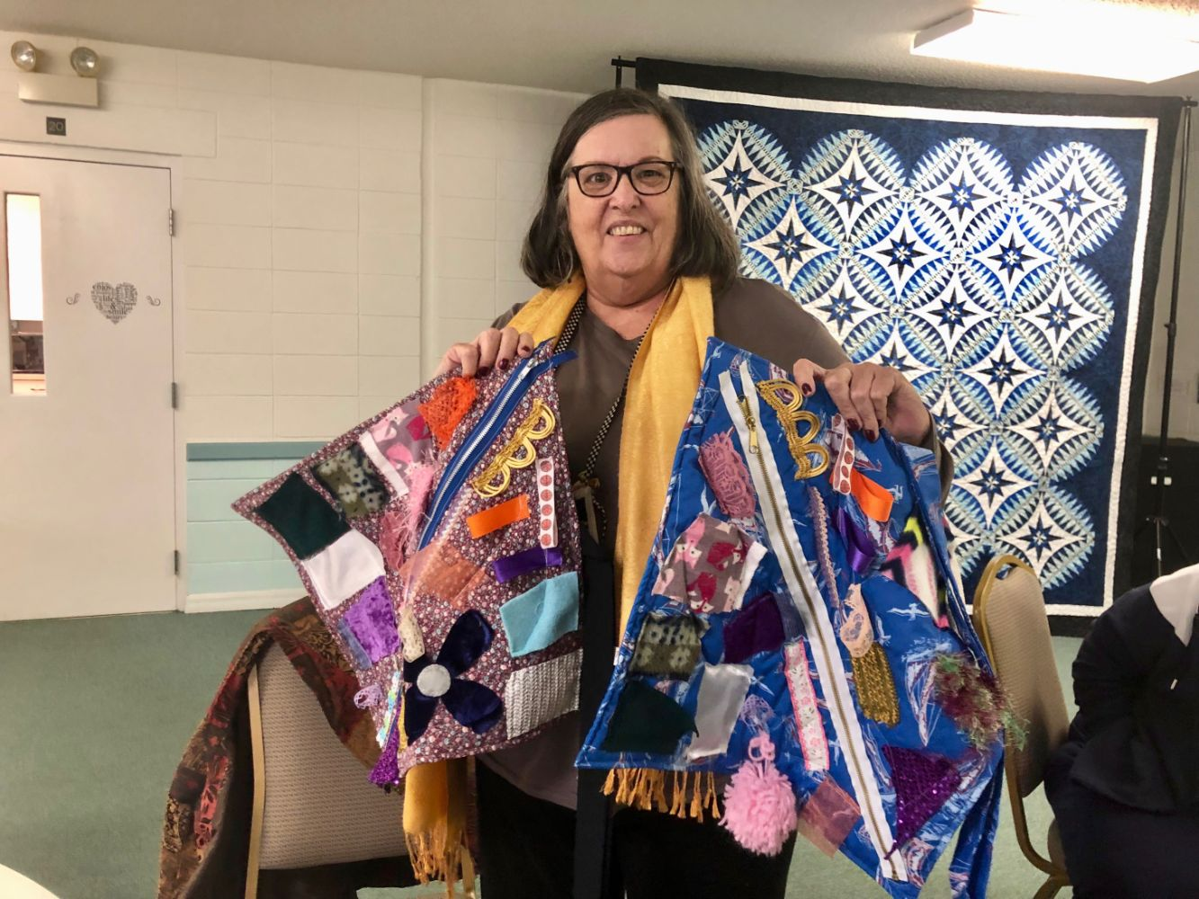 Racing Fingers Quilt Guild member Dee Duckworth holds two fidget quilts. Courtesy photo