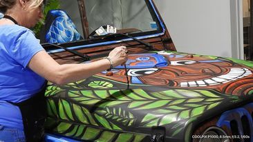Angel Lowden works on the Jiki Tiki logo on the hood of the Jeep. Courtesy photo