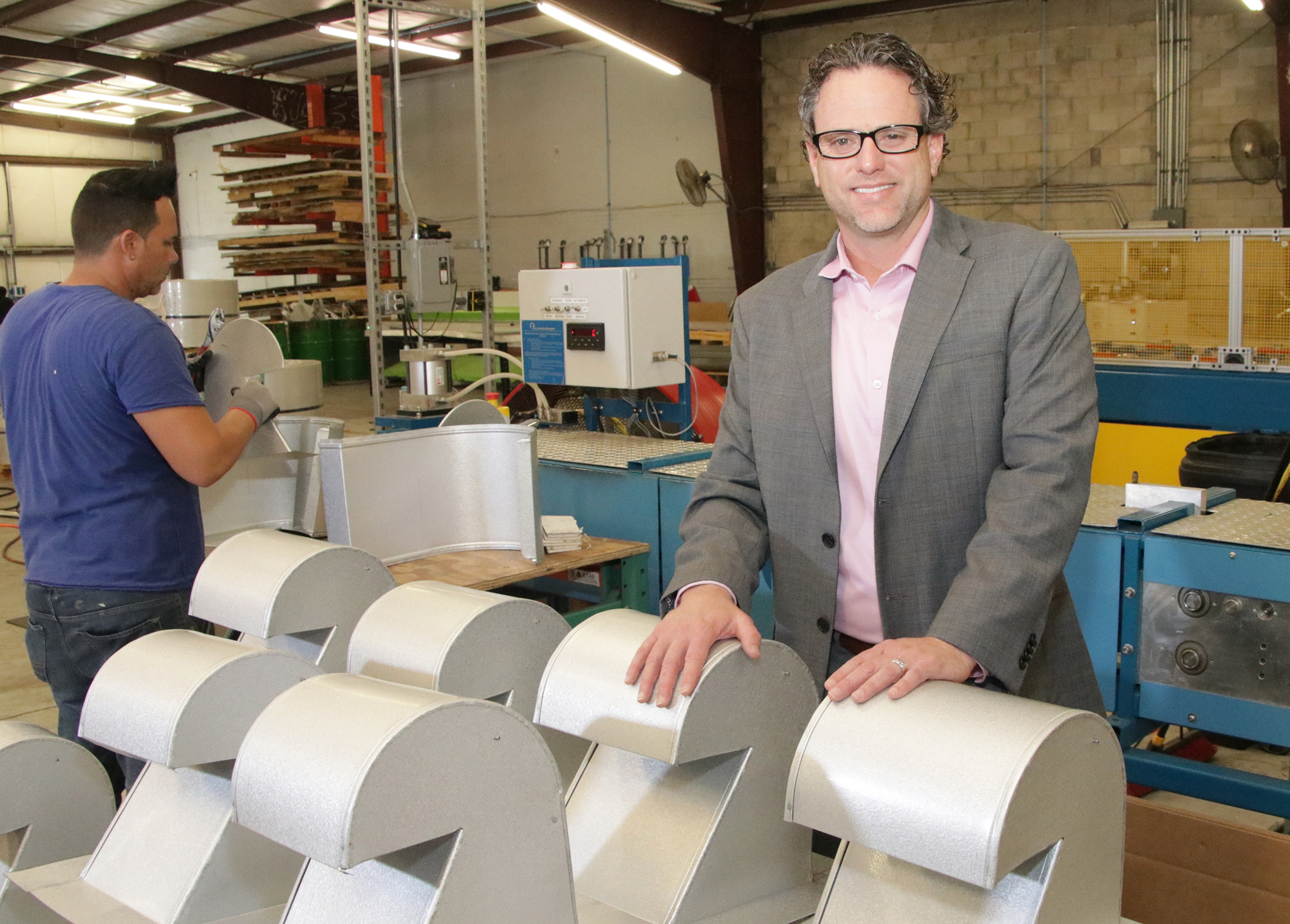 Jeffrey Bonk with samples of one of the roofing components made by Architectural Metal Flashings.