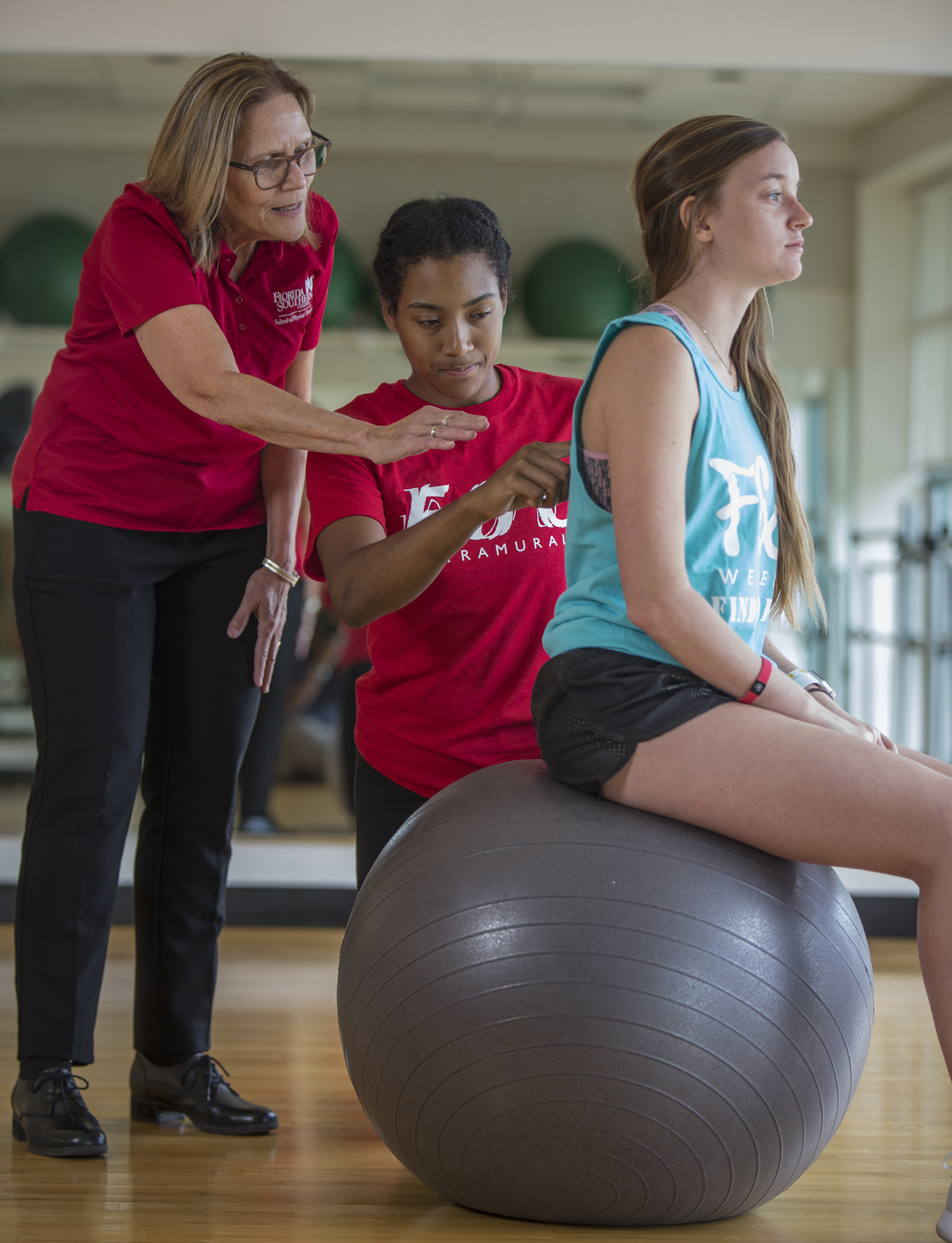 Calvin Knight. Florida Southern College School of Physical Therapy Program Director Nancy Nuzzo instructs Danae Moss as she examines Hannah Lewis.