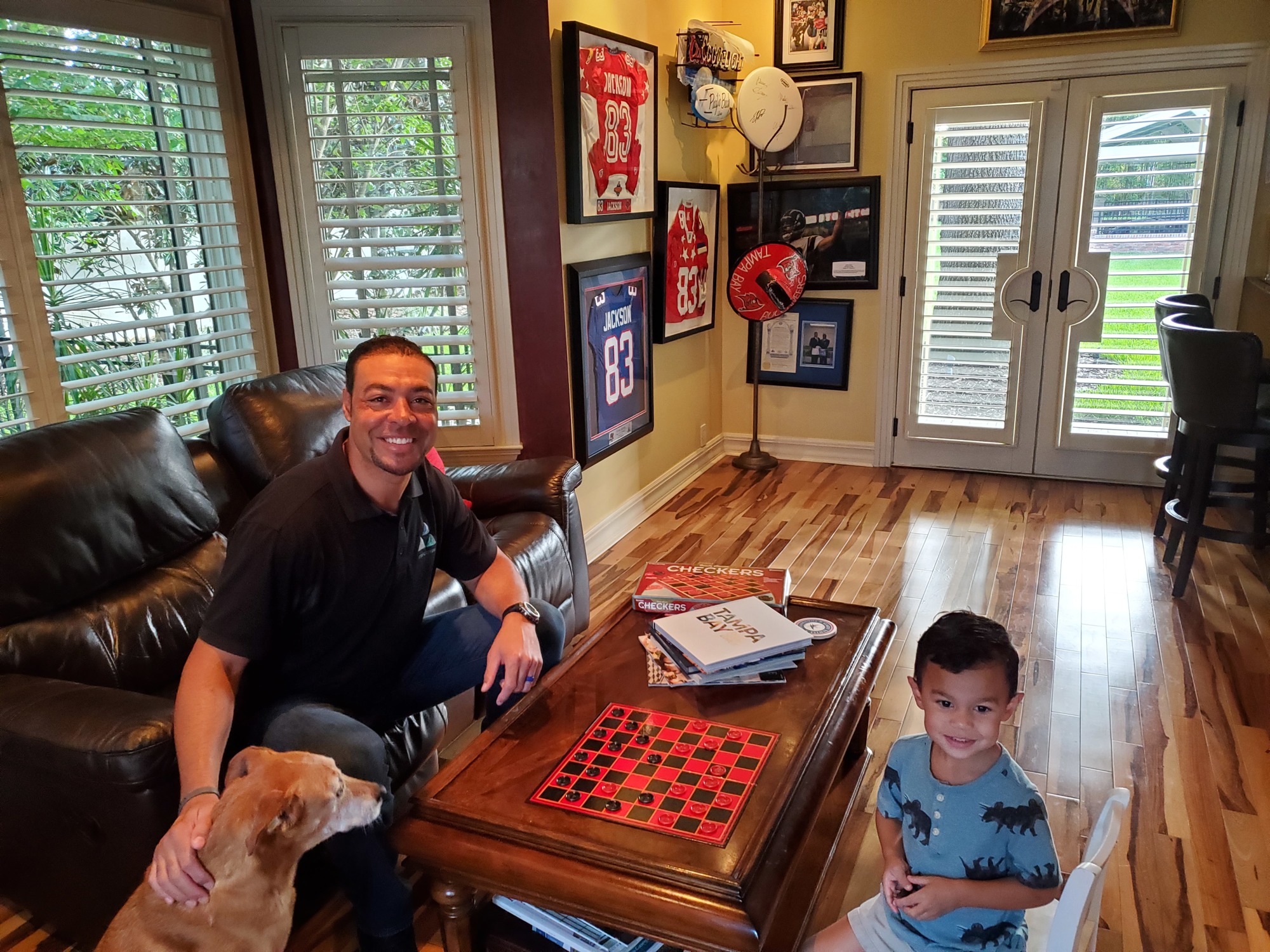 Courtesy. Vincent Jackson with his dog and son at his home office in South Tampa.