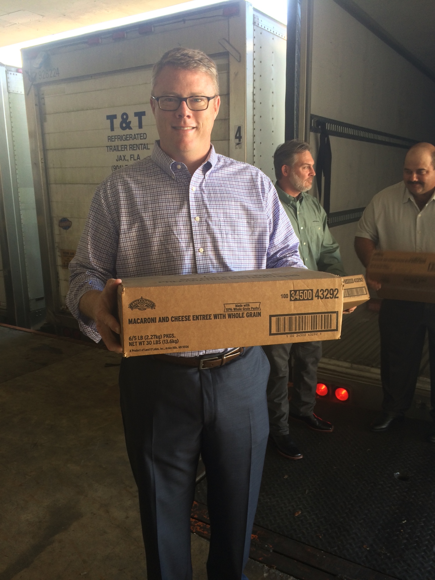Feeding Northeast Florida CEO Luke Layow carrying part of the 40,000-pound delivery of macaroni and cheese donated by Land O’Lakes Inc.