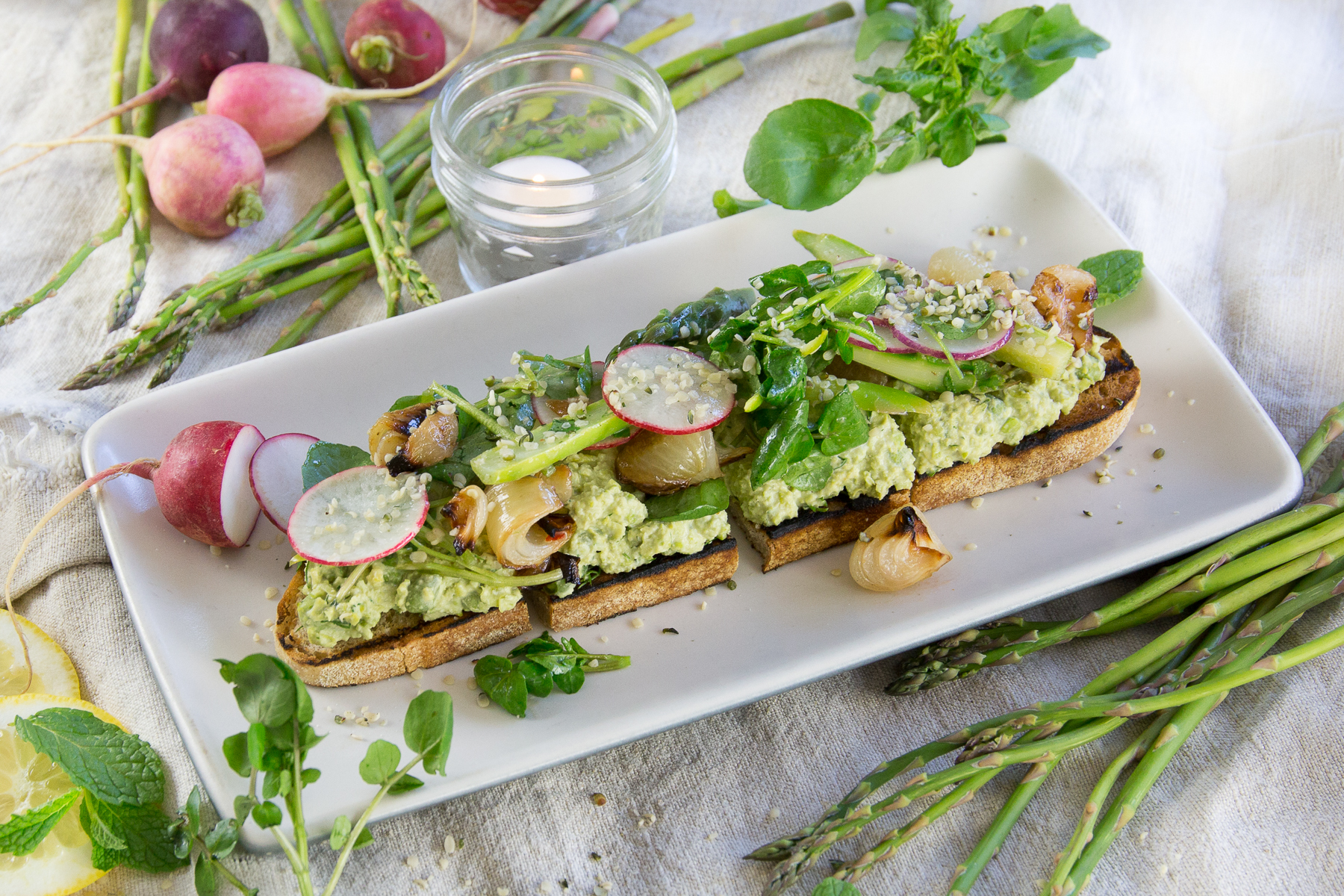 Spring asparagus toast is on the menu at True Food Kitchen. It features roasted cipollini onion, green garbanzo, tahini, mint and hemp seed.