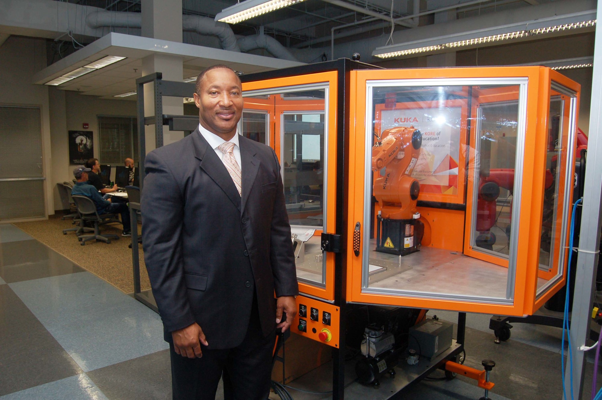 Florida State College at Jacksonville Associate Vice President of Workforce Development Cedrick Gibson with a training robot used by students enrolled in the advanced manufacturing career path.