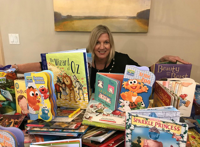 Riverside Homes representative Marjorie Taylor takes stock of the books collected by Riverside Homes during its March Into Literacy project.