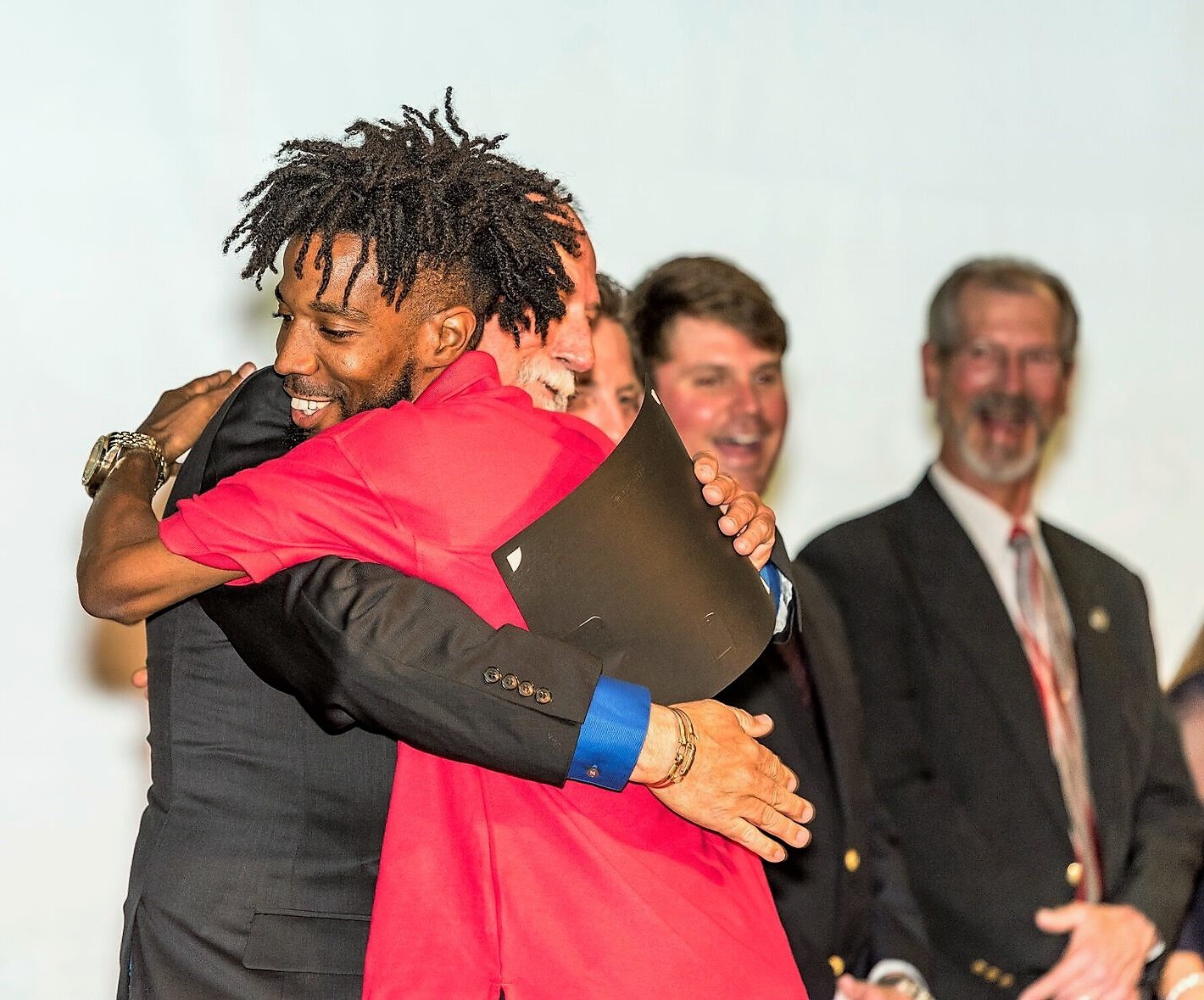 Keith Ward is embraced by Kaycee Cousins, an Electrical honors graduate who works for Advanced Wiring Services Inc.
