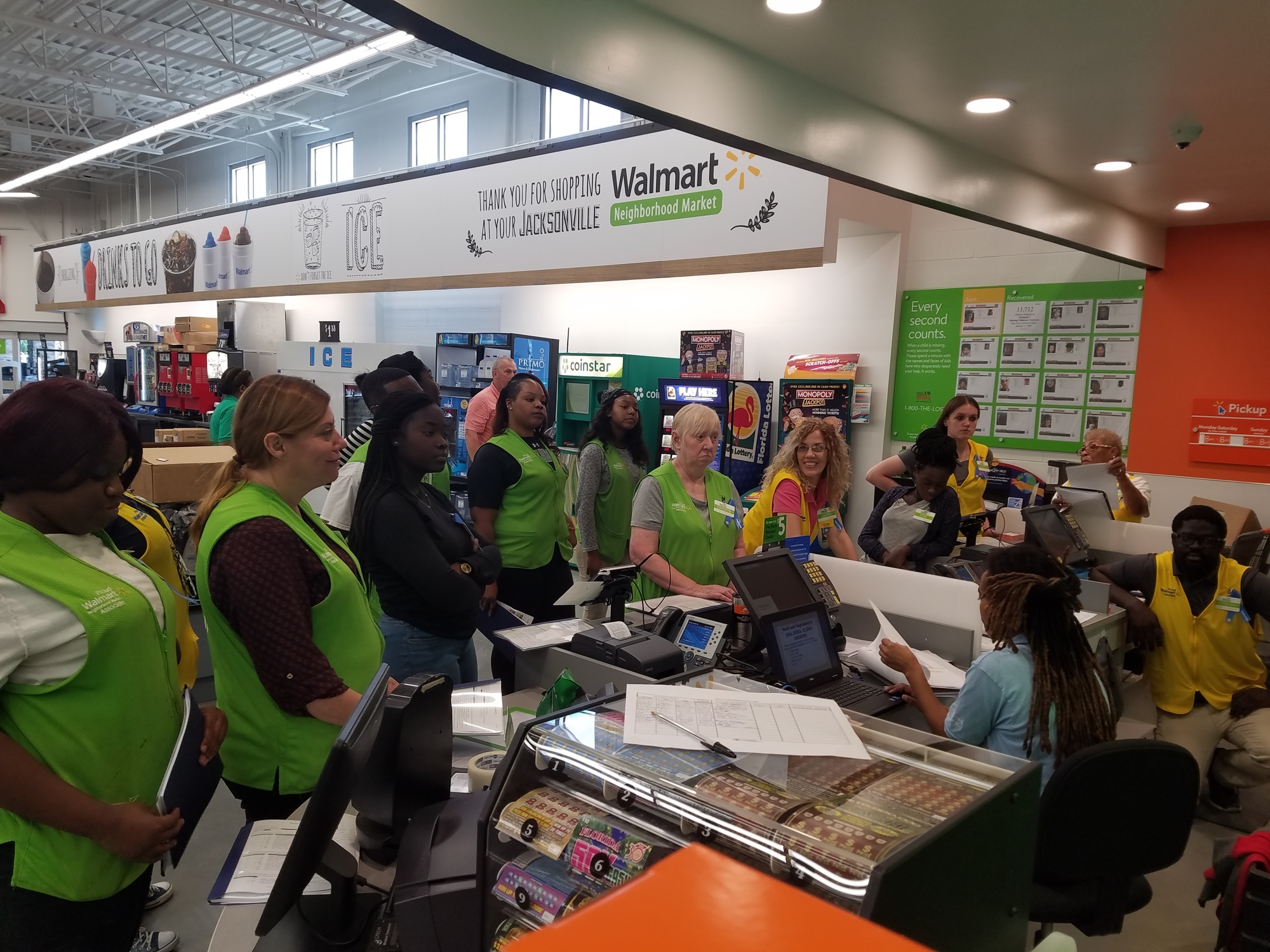 Workers hired at the Walmart Neighborhood Market on Baymeadows Road gather around the front desk for directions from managers in preparation of the store's opening Wednesday.