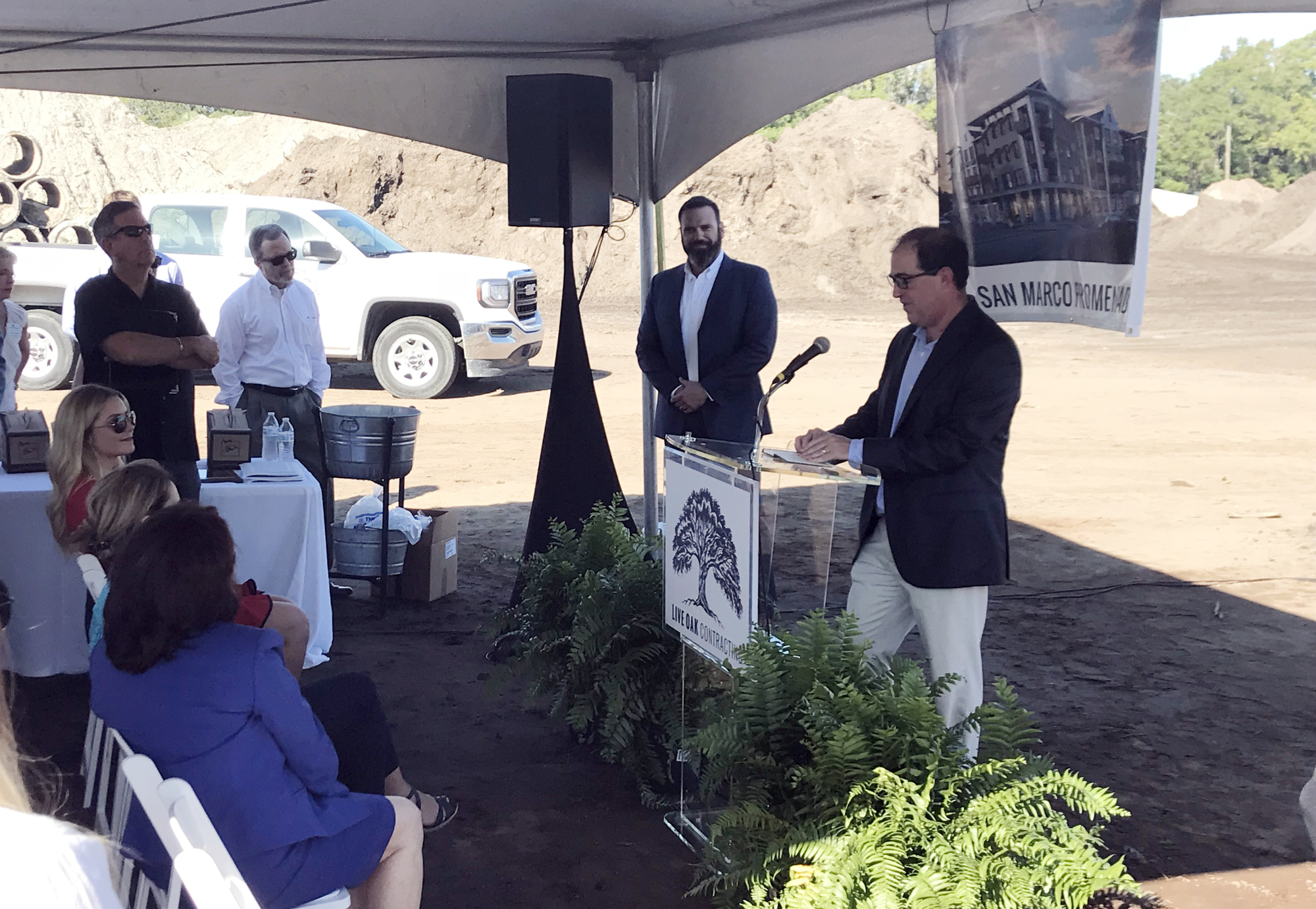 Paul Bertozzi, the president and CEO of Live Oak Contracting, watches as Jeffrey Rosen, a principal partner with Chance Partners, speaks at the groundbreaking ceremony Tuesday.