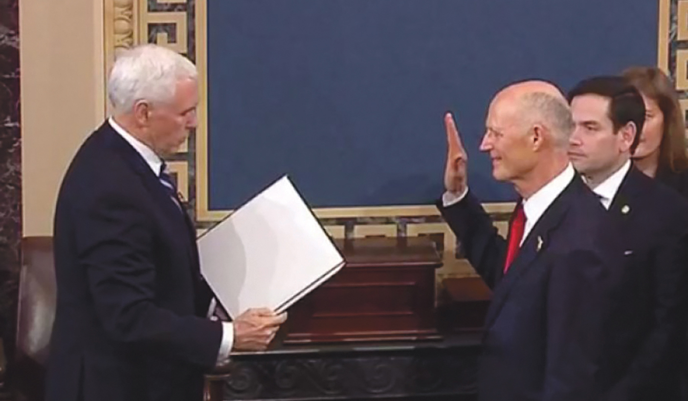 U.S. Sen. Rick Scott is sworn in by Vice President Mike Pence on Tuesday while Sen. Marco Rubio watches.