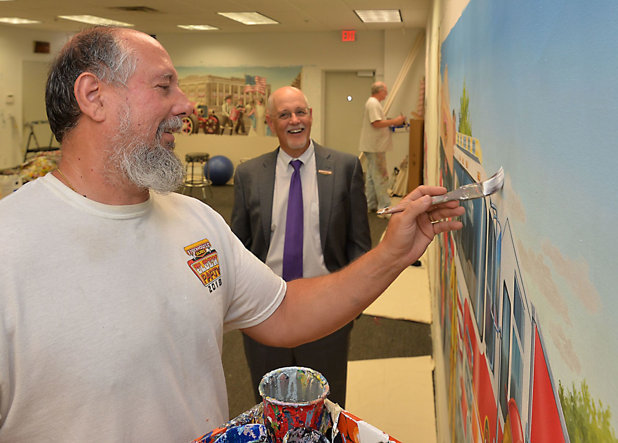 Firehouse Subs CEO Don Fox watches Joe Puskas, the company’s chief mural artist, work in the Firehouse Subs headquarters studio in South Jacksonville. Firehouse says Puskas and his team have painted more than 1,165 murals.