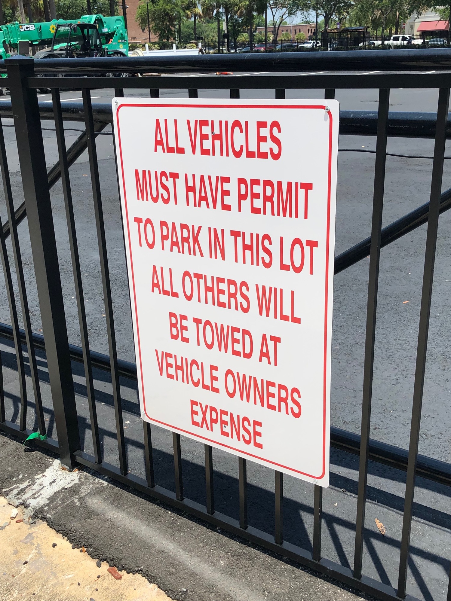 Signs at the empty lot warn that a permit is needed to park there.