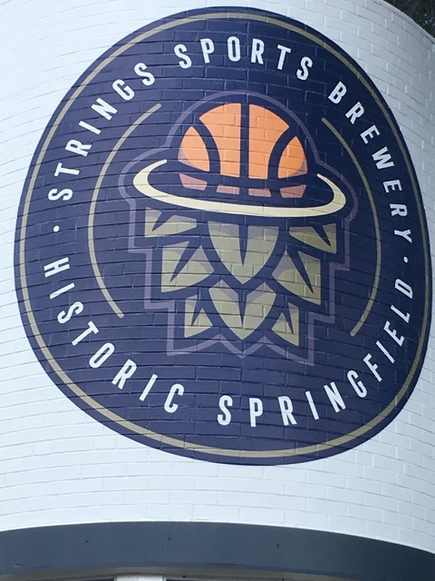 The logo for Strings features a basketball. The brewery has a regulation-height hoop where customers can shoot free throws.