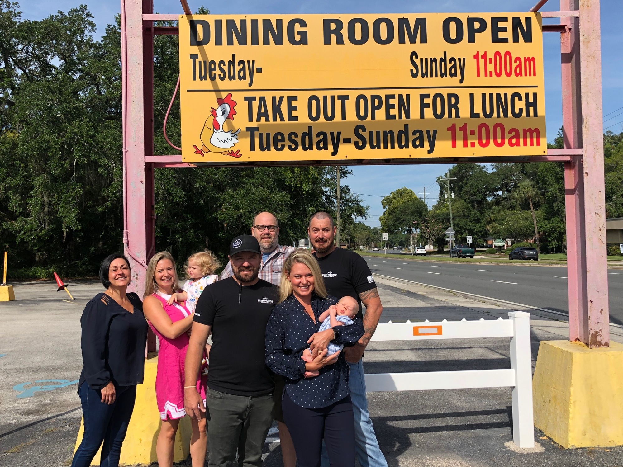 The Beach Road Chicken Dinners owners and leadership gather under the restaurant's sign.