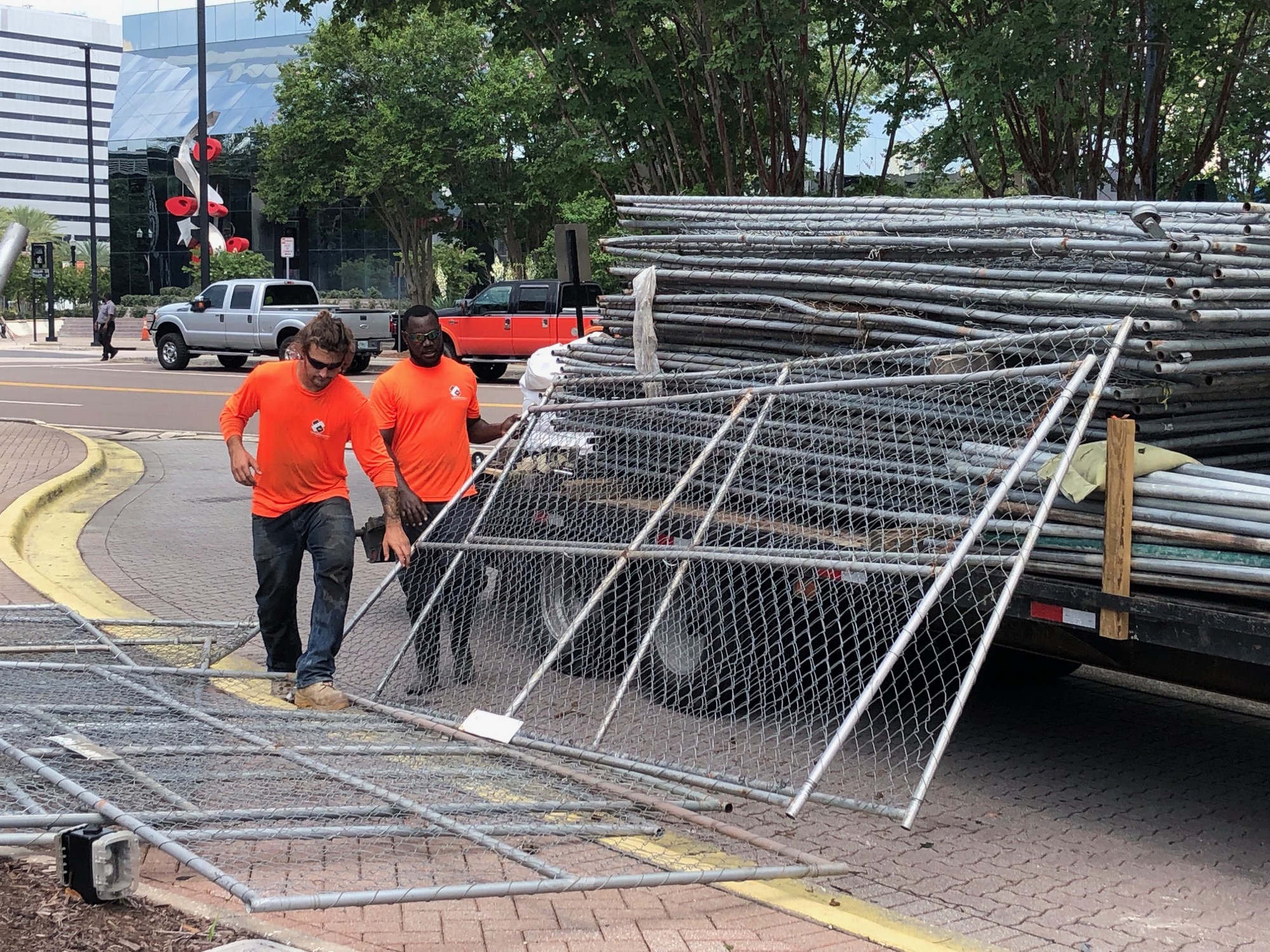 Workers from Armstrong Fence Co. put up barriers Thursday around The Jacksonville Landing.
