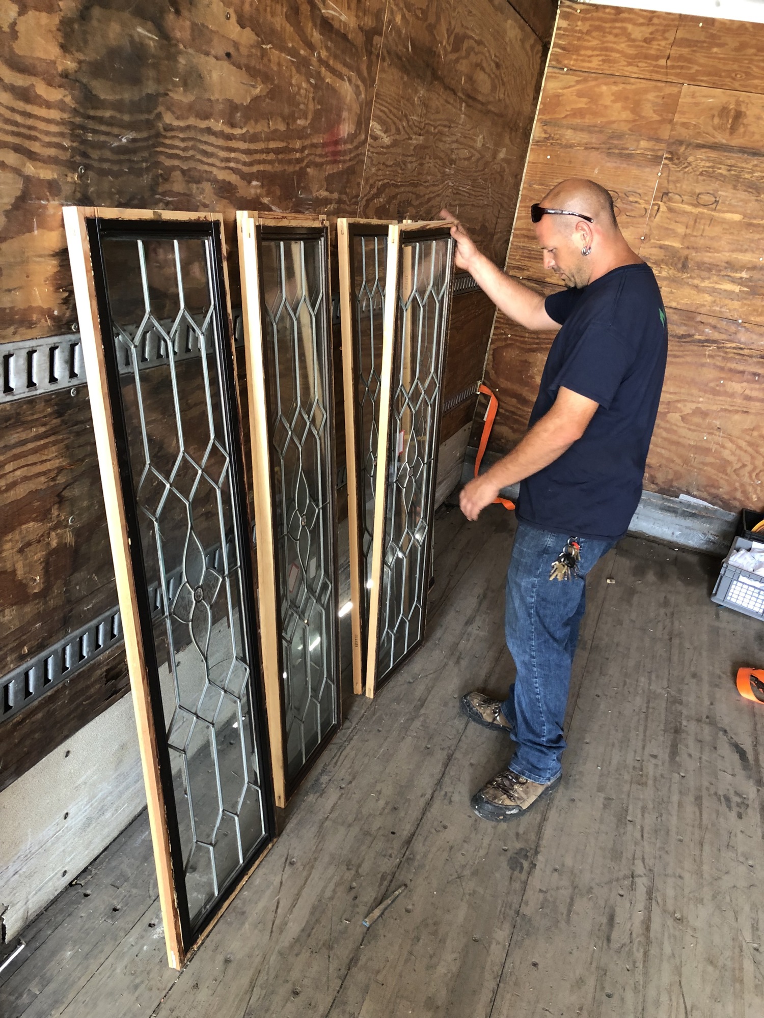 Eco Relics manager John Cooper examines salvaged glass windows.
