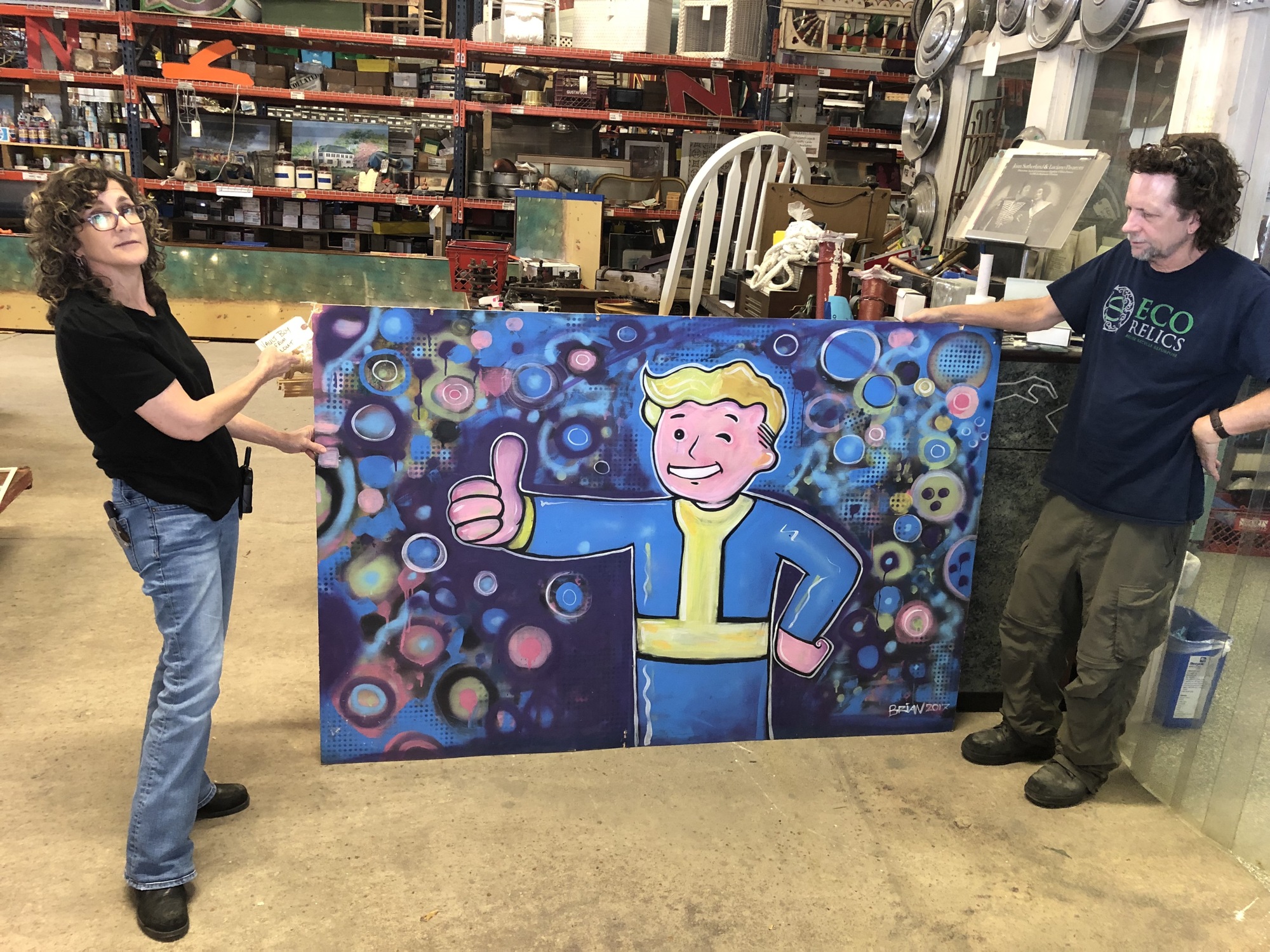 Eco Relics owners Annie and Michael Murphy with the mural of Vault Boy from the Fallout video game series.