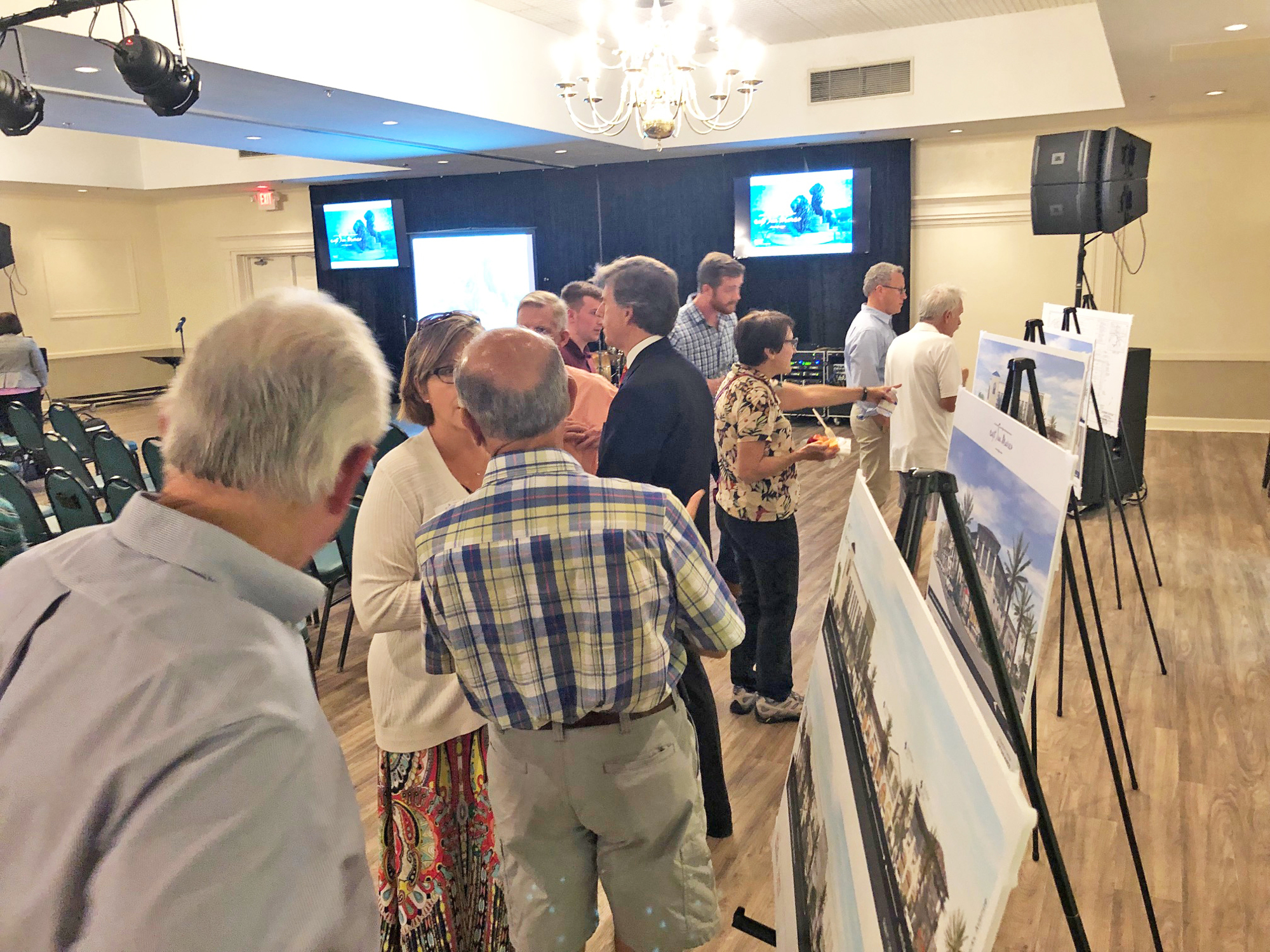 Town hall meeting attendees check out artist renderings of the East San Marco shopping center.