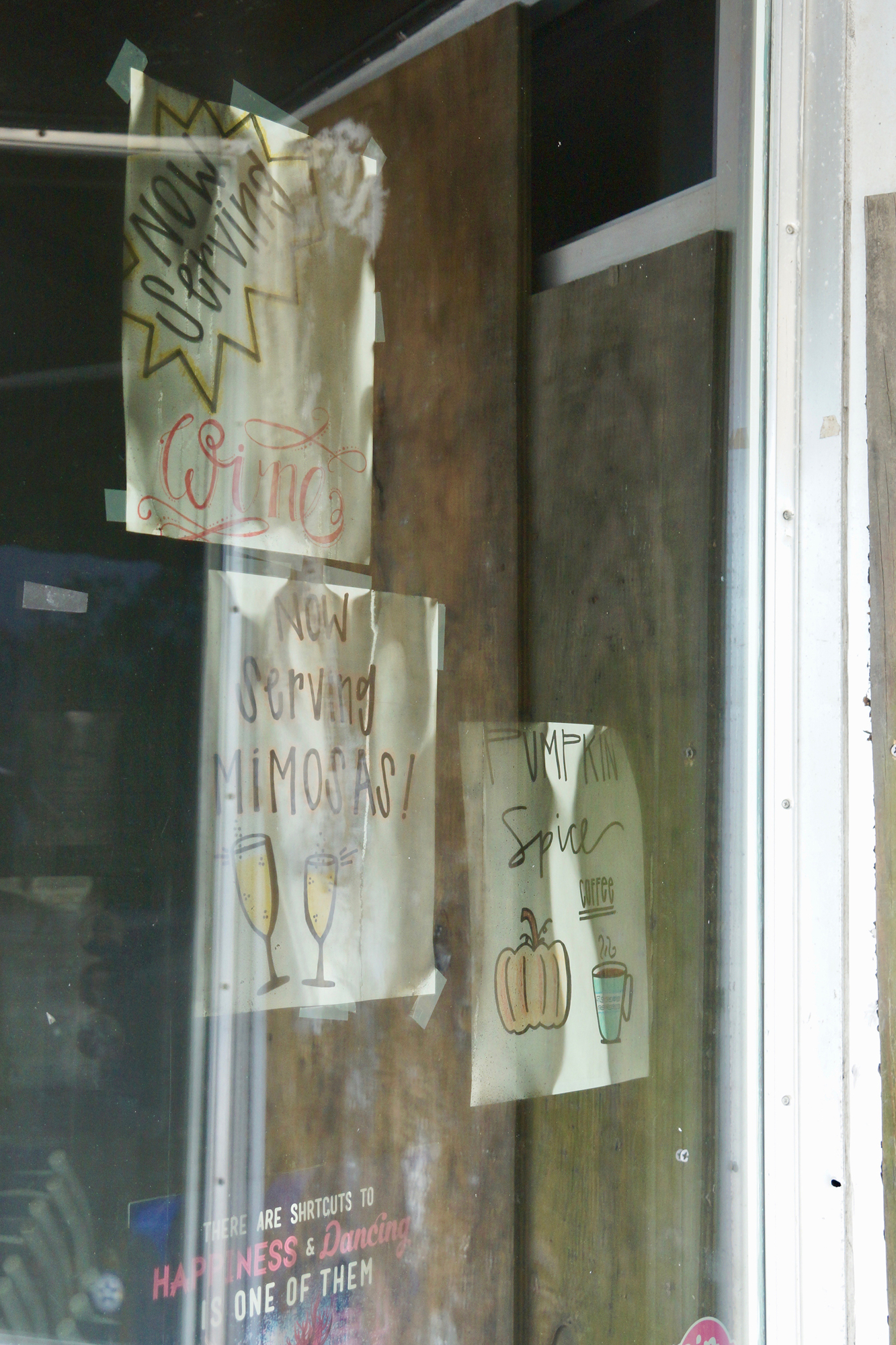 Smoke-stained signs in the window of Beach Dinner.