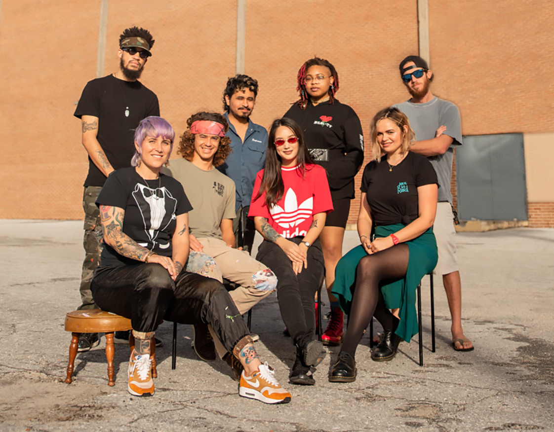 Mural artists: Seated, bottom row from left, Nicole “Nico” Holderbaum, Anthony Rooney, Elena Ohlander and Ansley Randall. Standing, top row, from left: Christopher Clark, Martin “Tilin” Torres, Tatiana Kitchen and Steven Teller.