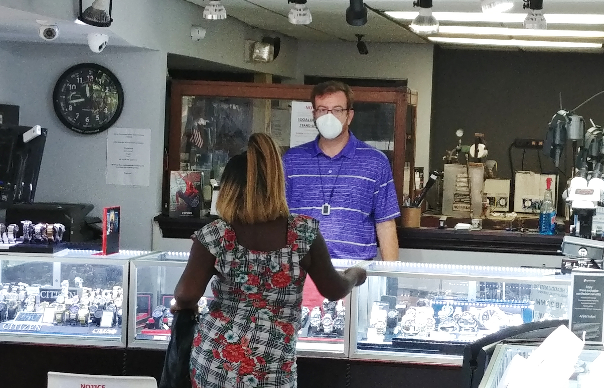 At Hemming Plaza Jewelers at 231 N. Hogan St., co-owner Juan Gonzalez serves a customer inside the store. The store didn’t close because of the pandemic, serving customers curbside.