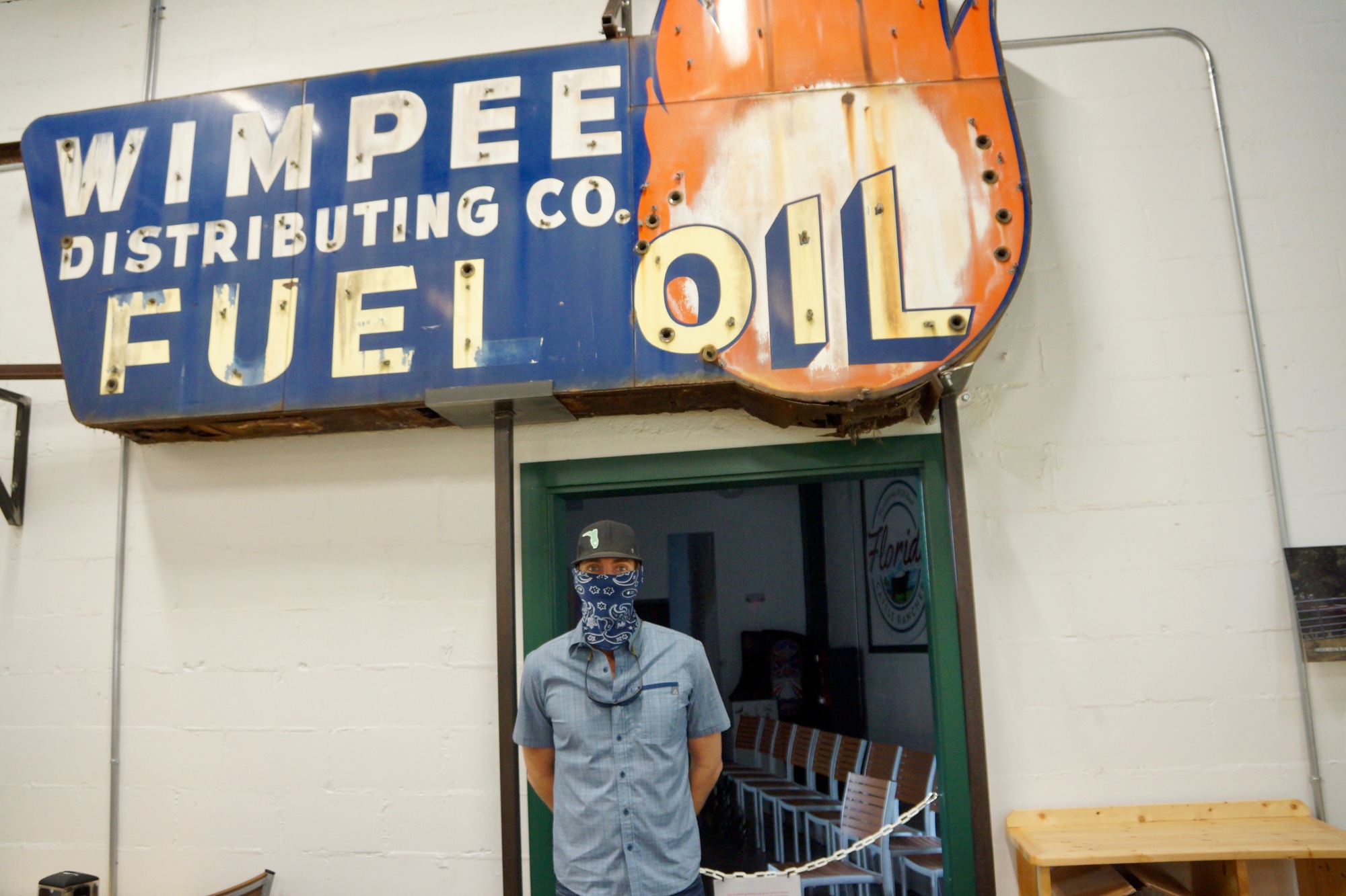 Travis Norman stands under the Wimpee Fuel Oil sign, which was on the original building in 1937. The sign hangs in the restaurant’s main dining room.