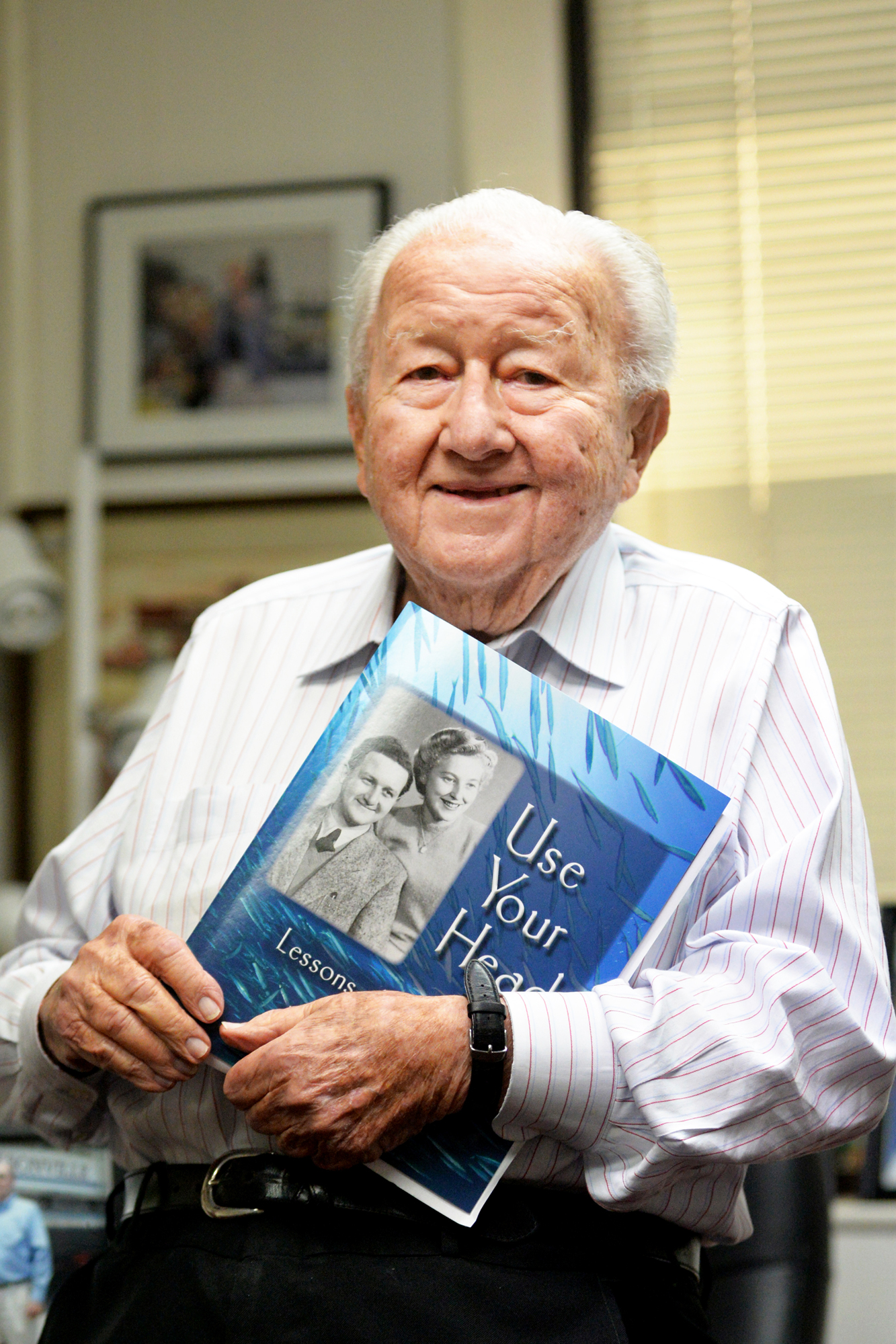 Beaver Street Fisheries Inc. Chairman Harry Frisch holds his 2018 biography, “Use Your Head: Lessons of a Lifetime.”