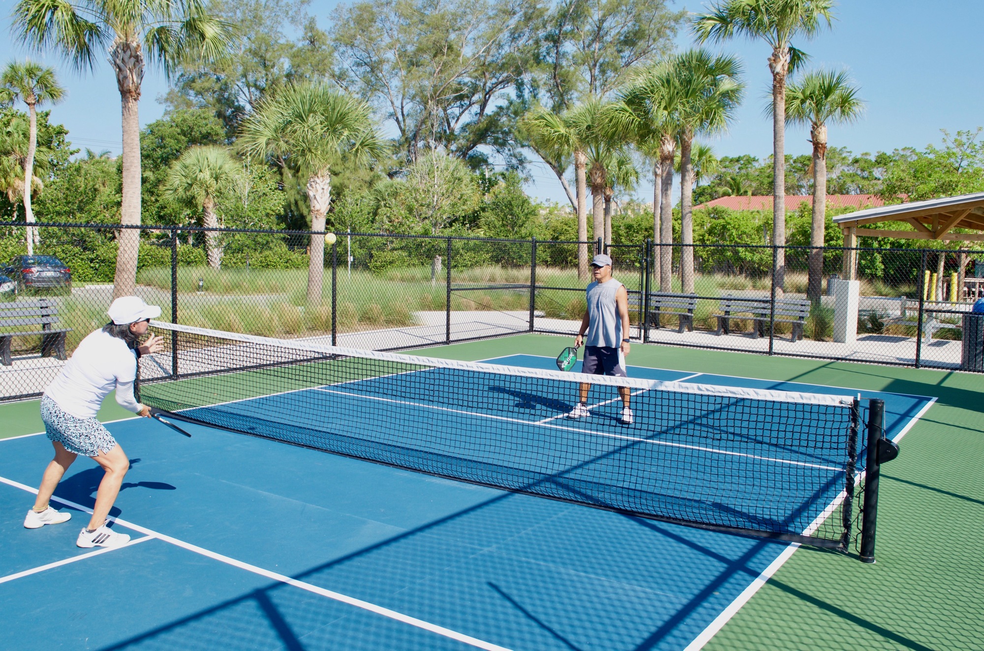 Pickleball is played on a badminton-sized court that measures 44 feet by 20 feet. Players use paddles to hit the hollow, plastic balls.