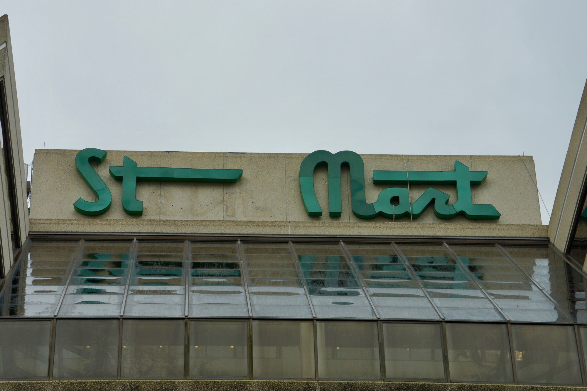 Workers continue removing letters from the  Stein Mart headquarters sign.