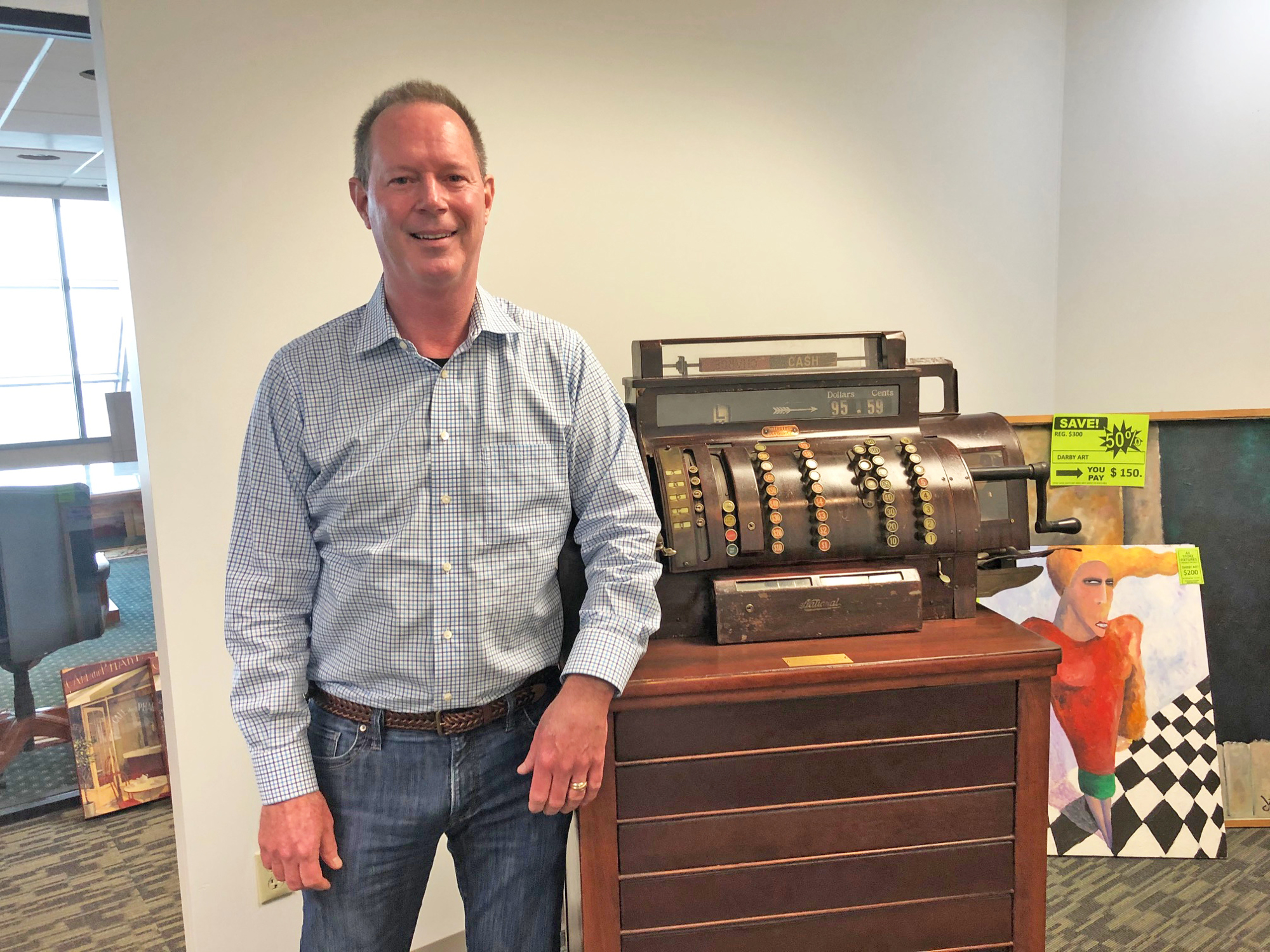 Stein Mart CEO D. Hunt Hawkins with the cash register used in the original Stein Mart store in Greenville, Mississippi, during the 1940s and 1950s. It was donated to the Museum of the Southern Jewish Experience in North Orleans.