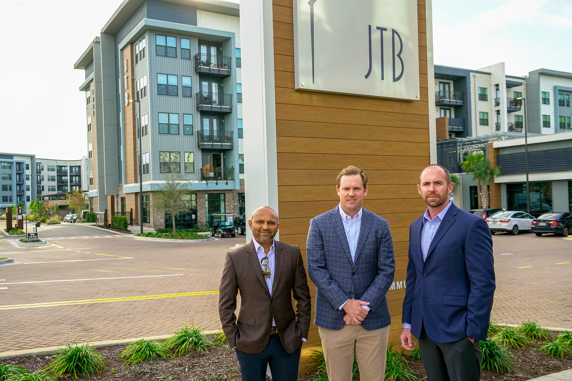 Dhaval Patel, Brian Moulder and Bobby Gatling of Walker & Dunlop in front of JTB Apartments on AC Skinner Parkway, which they sold for $83.25 million.