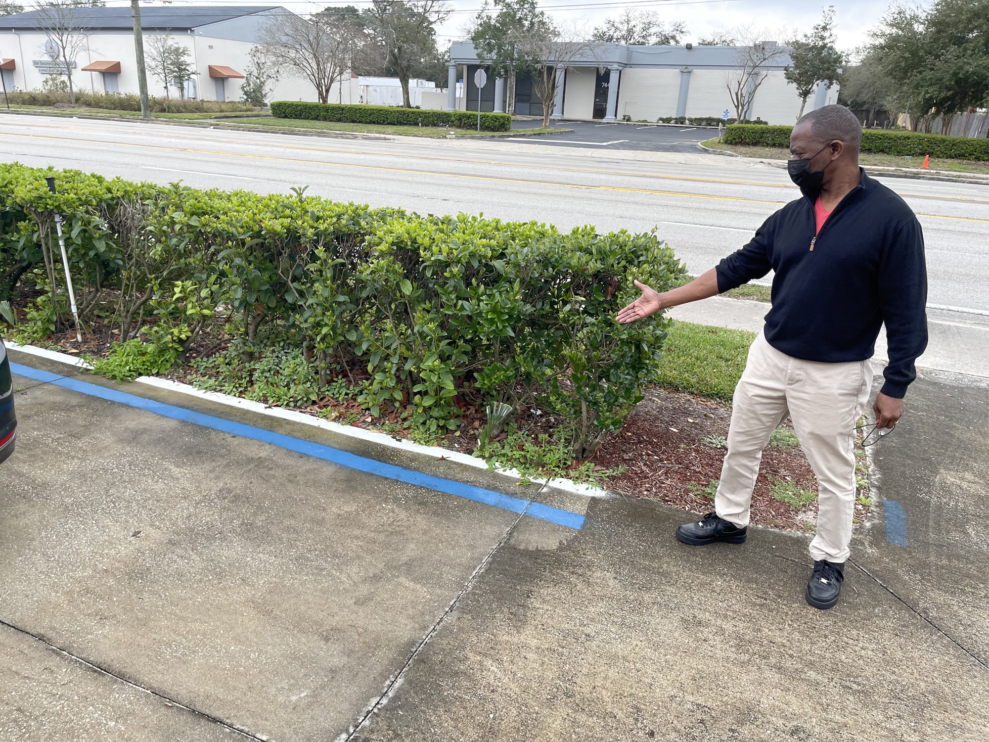 Aaron Gipson, owner of Hair Formations Salon at 7435 Merrill Road, shows an area of his property that needs to be brought into compliance.